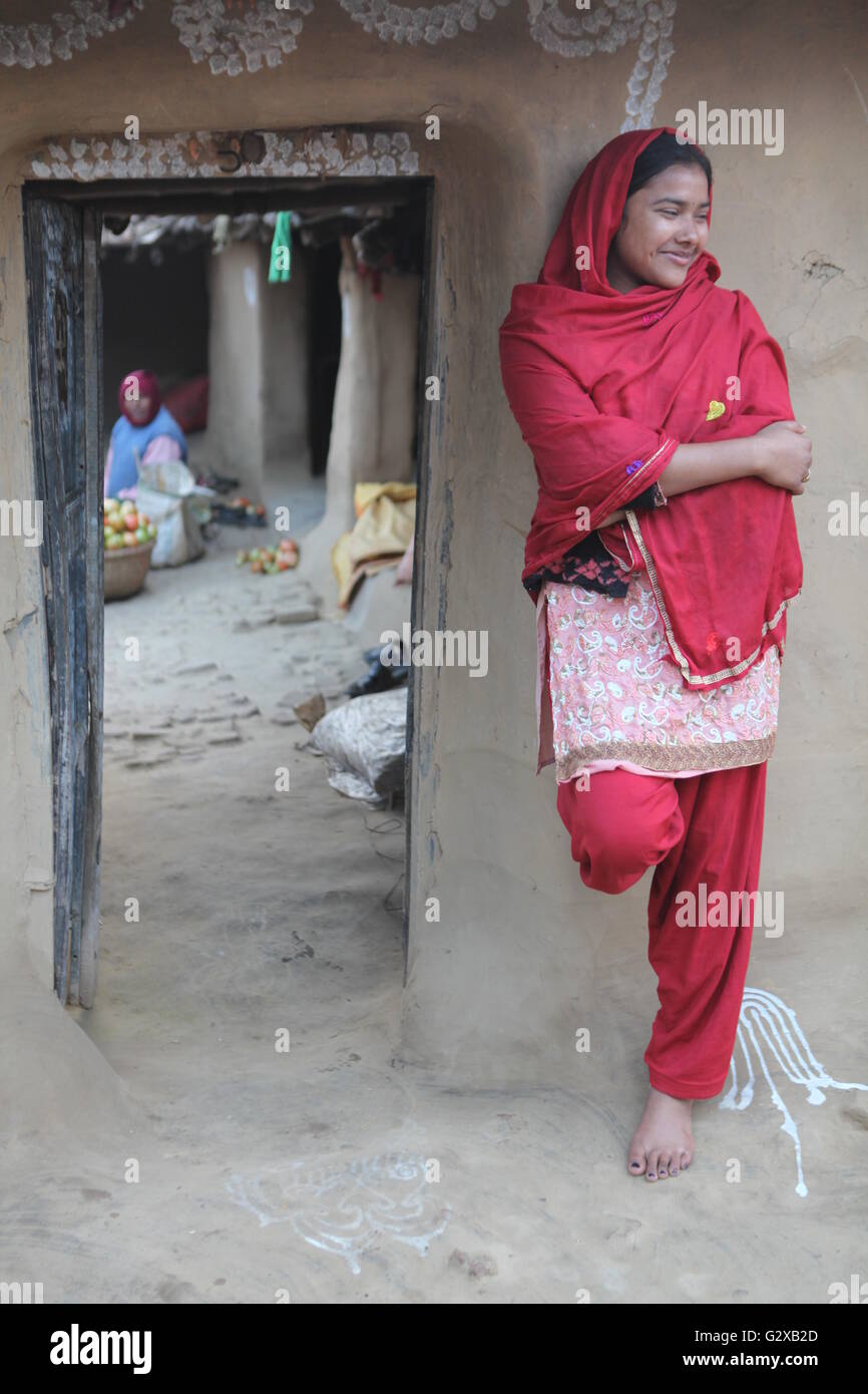 a village girl clad in traditional pyjama and kurta,at the door of her house Stock Photo