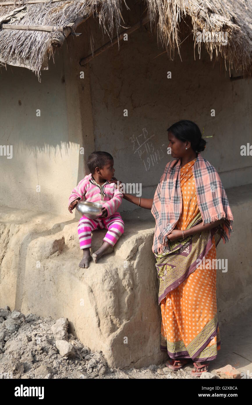 a tribal woman feeding her child in raiganj,west bengal Stock Photo