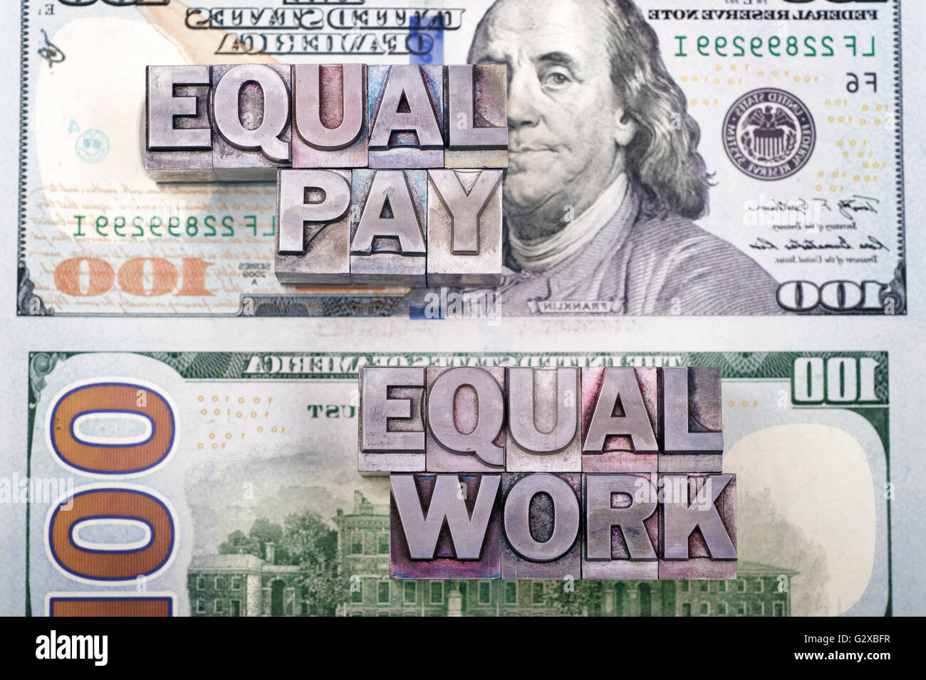 equal pay for equal work concept made from metallic letterpress type on US dollar banknotes Stock Photo