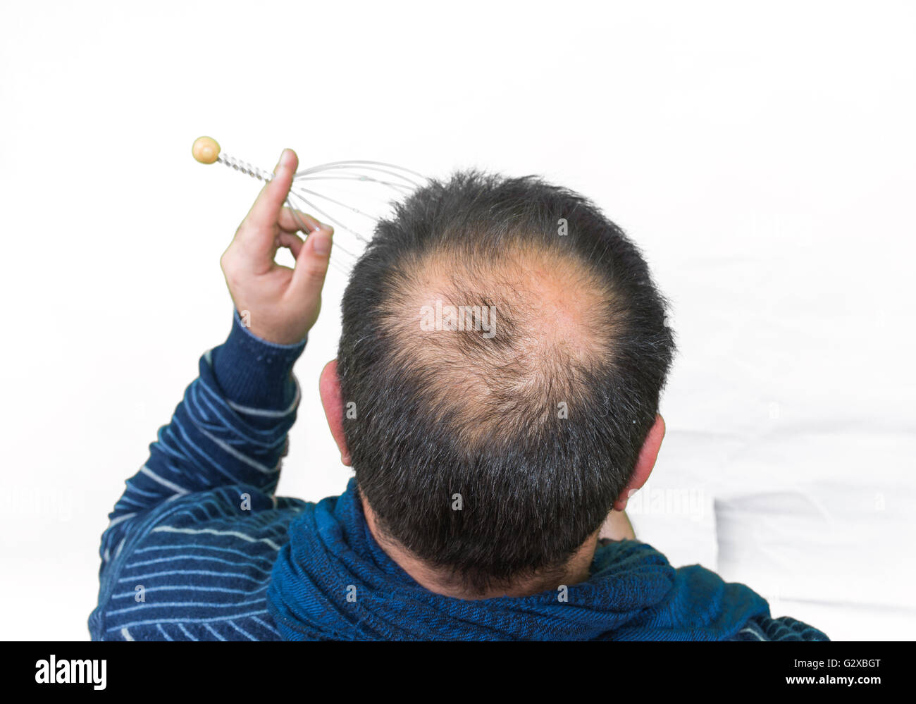 Man relaxes with the Genie head massager. Alternative Therapy. Indian