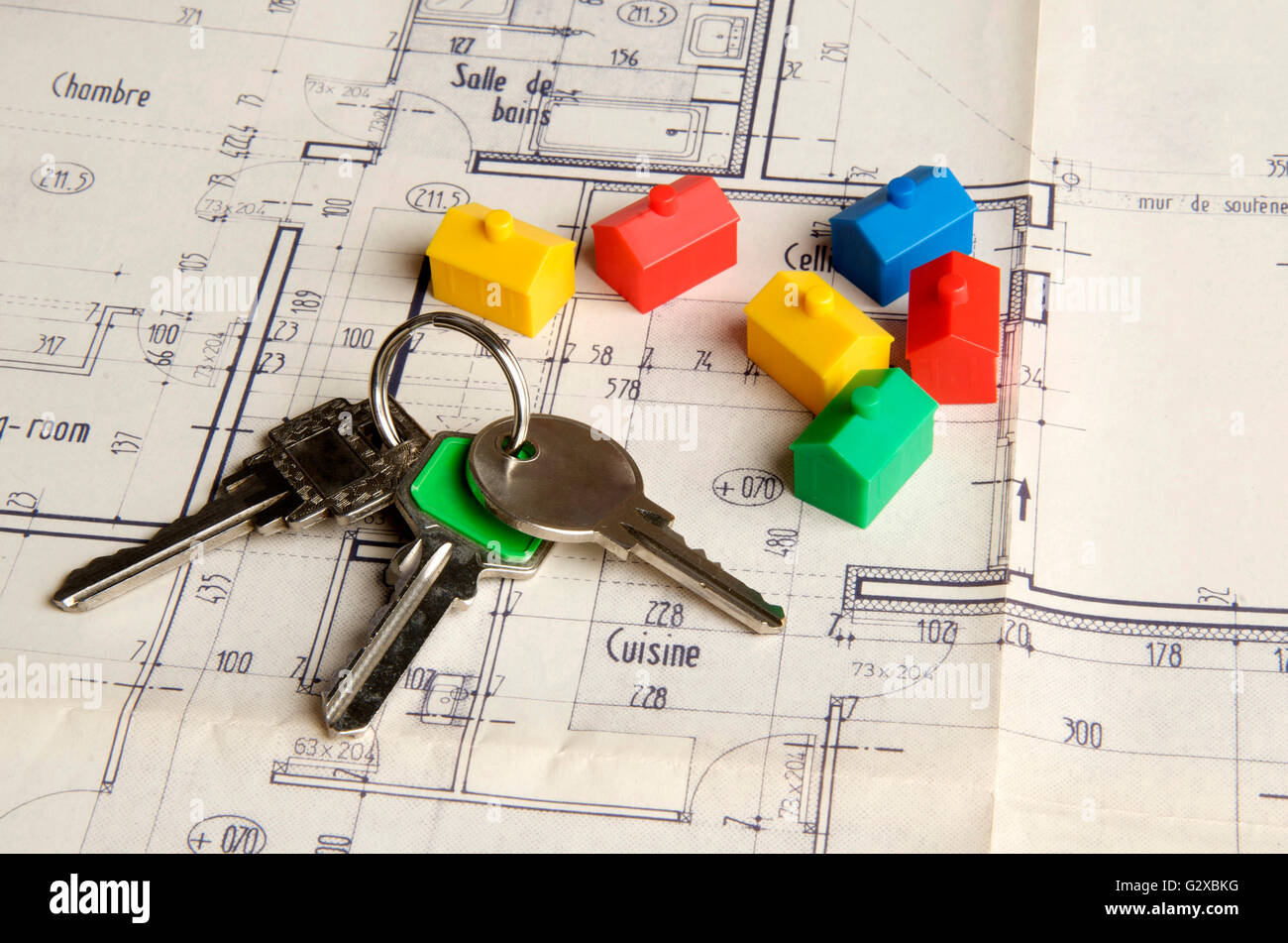 House keys and miniature houses on a construction plan, symbolic image for real estate market, France Stock Photo
