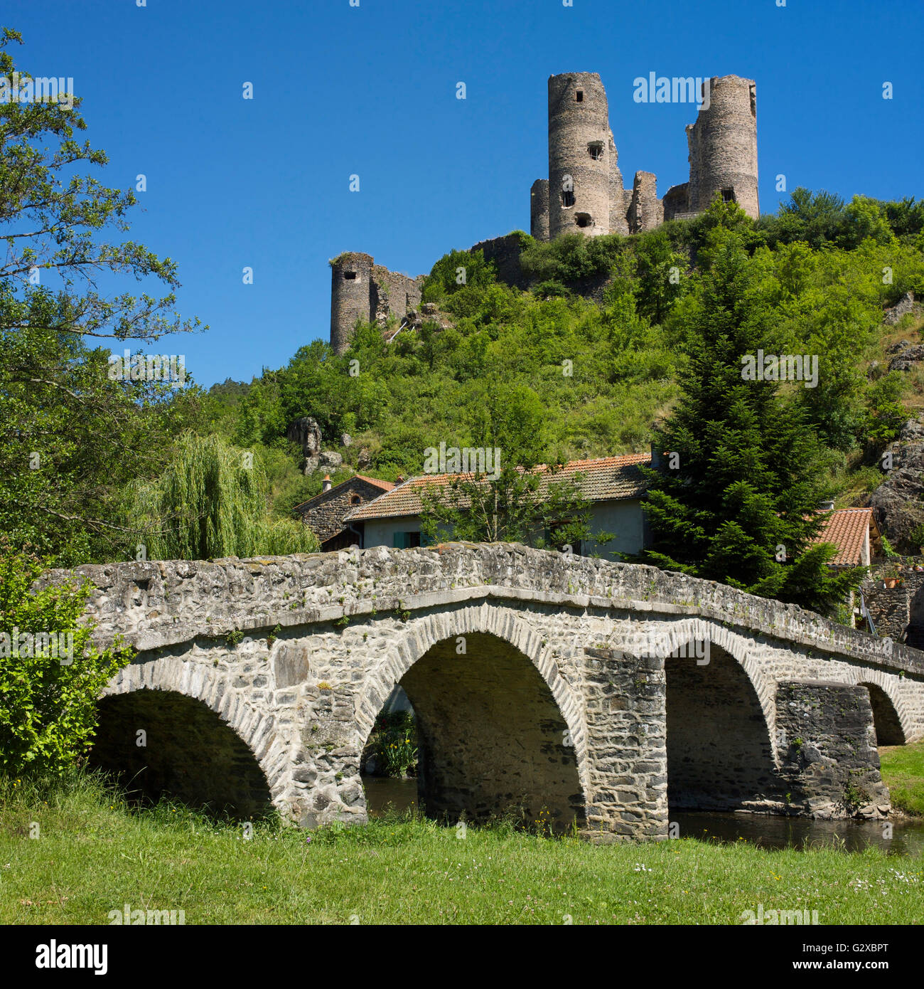 Old stone bridge in front of Château de Domeyrat castle, Domeyrat, Haute-Loire department, Auvergne, France Stock Photo