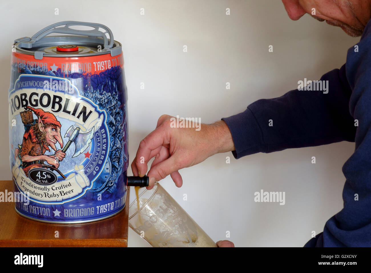 man pouring a pint of hobgoblin ruby beer from wychwood brewery england Stock Photo
