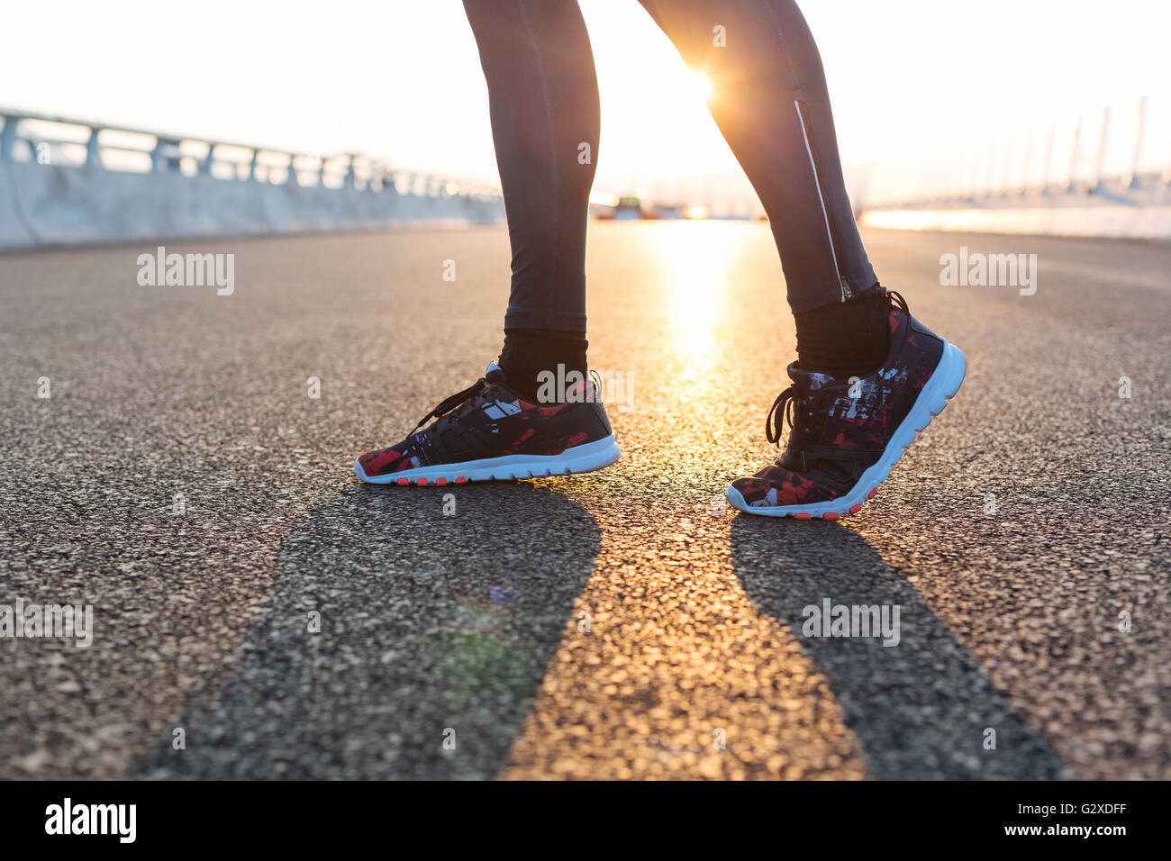 fitness sunrise jog workout welness concept. Runner feet running on road closeup on shoe Stock Photo
