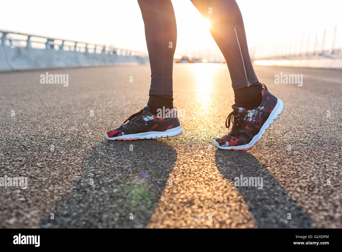 fitness sunrise jog workout welness concept. Runner feet running on road closeup on shoe Stock Photo
