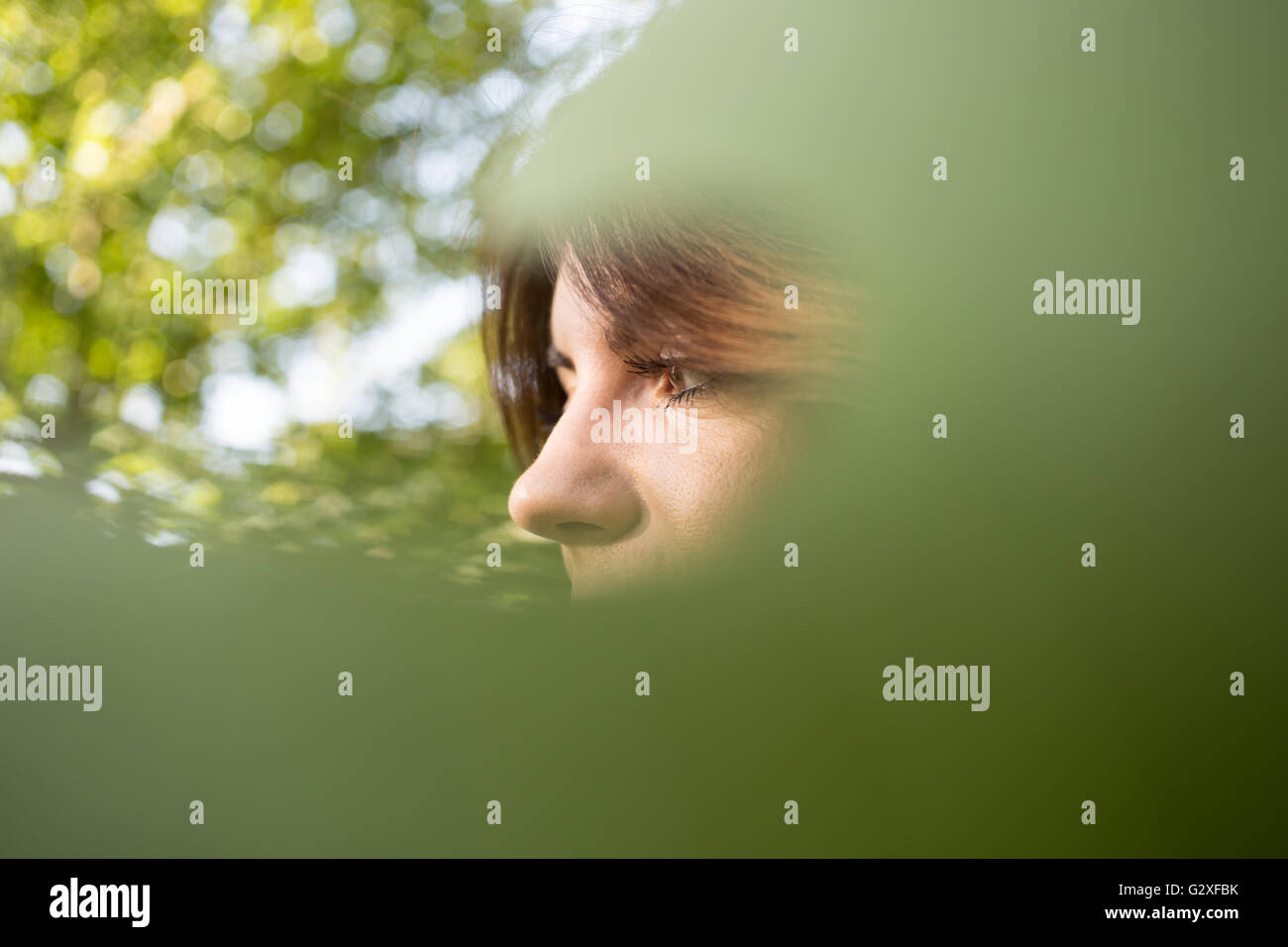 Face of beautiful woman is covered by green leaf, concept of beauty and ...
