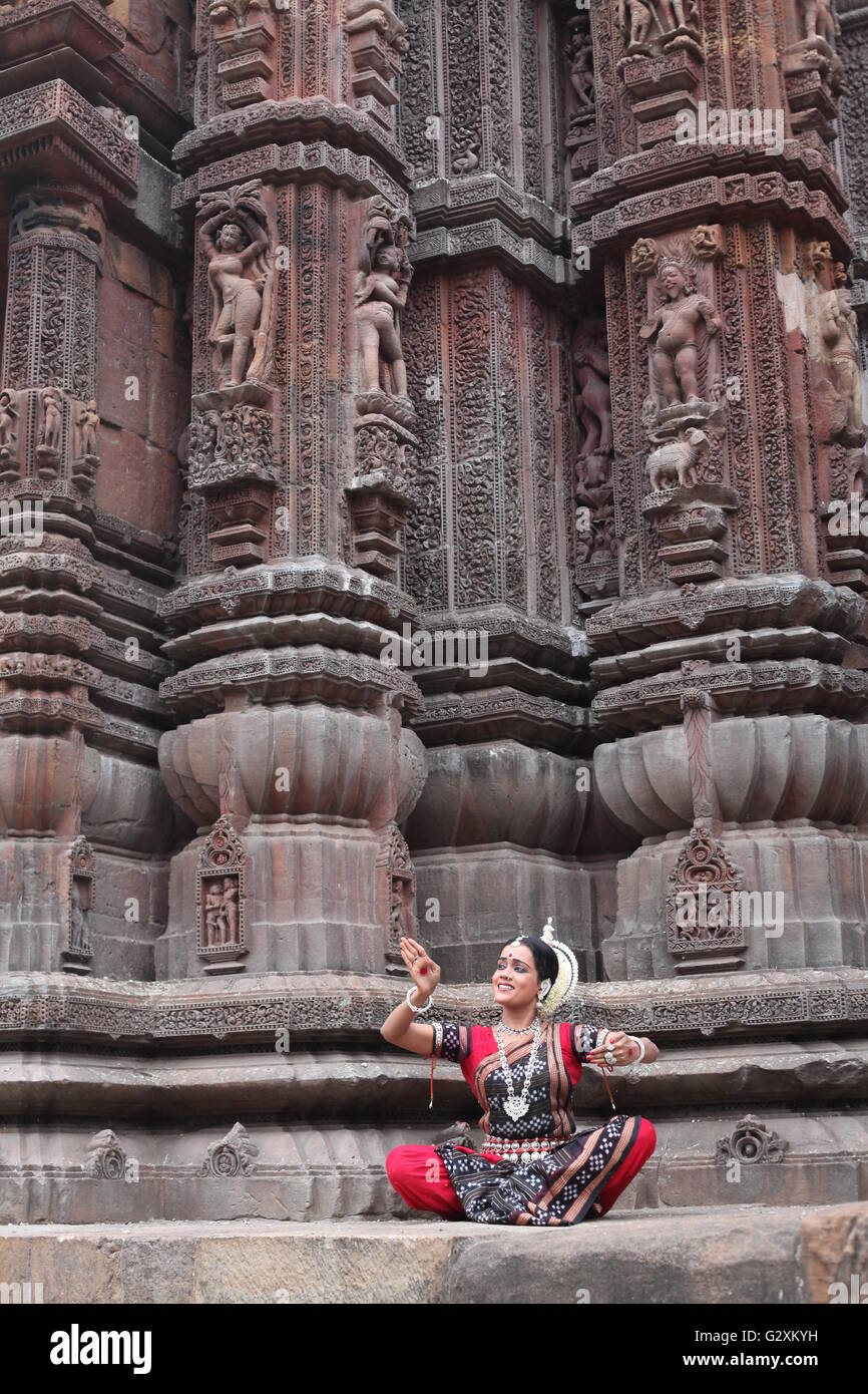 odissi dancer dancing before a temple with relevant dance sculptures in bhubaneswar Stock Photo