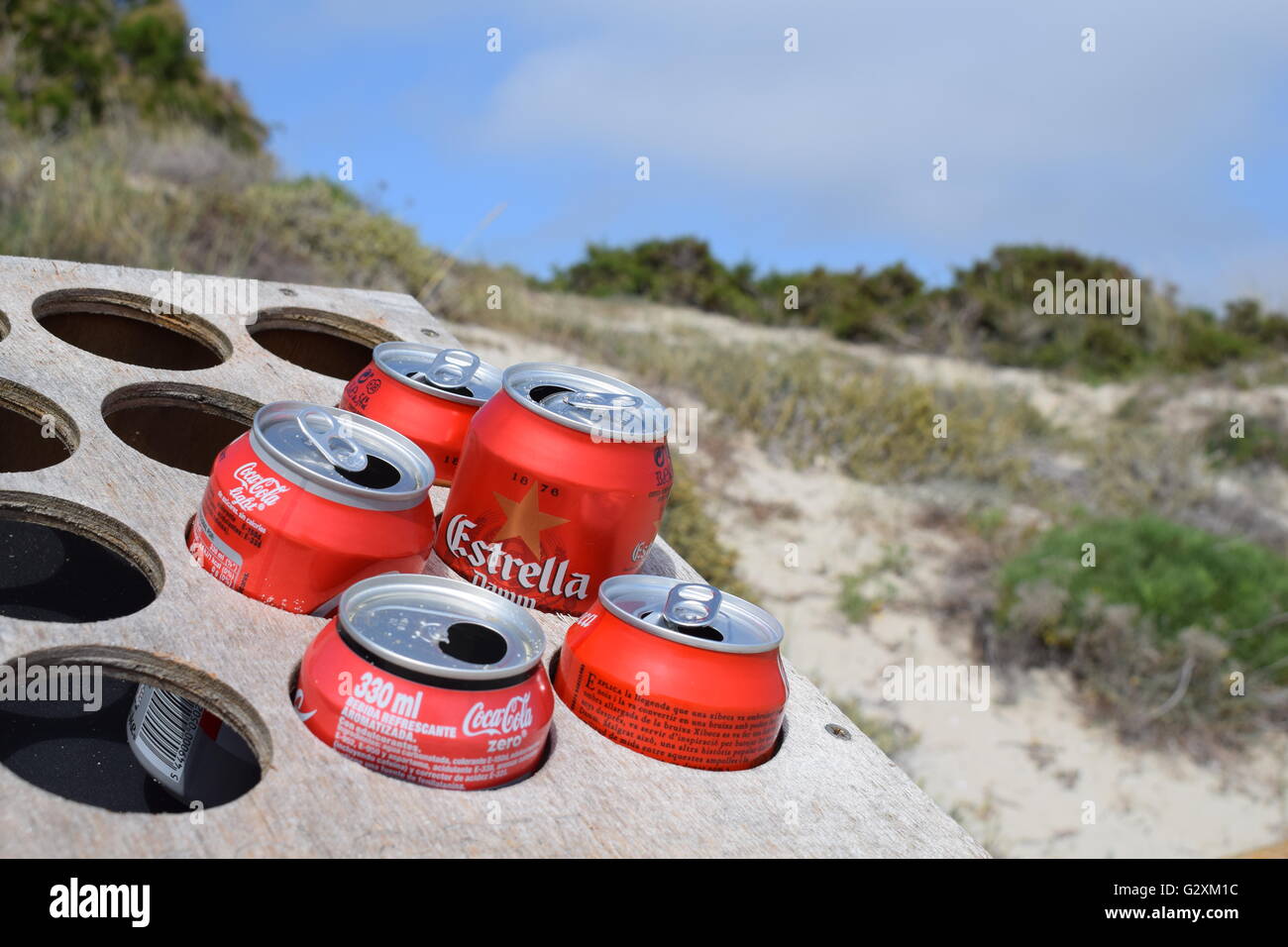 Coke and beer cans recycled as cigarette ash trays Stock Photo