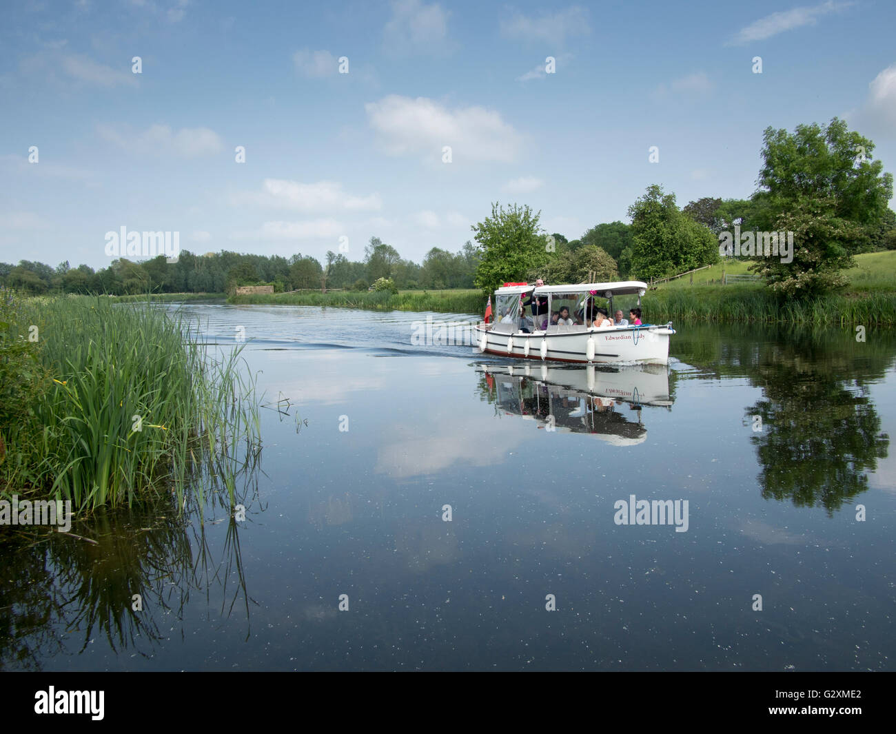 People enjoying a boat cruise on the River Stour in Sudbury, Suffolk, England. Stock Photo