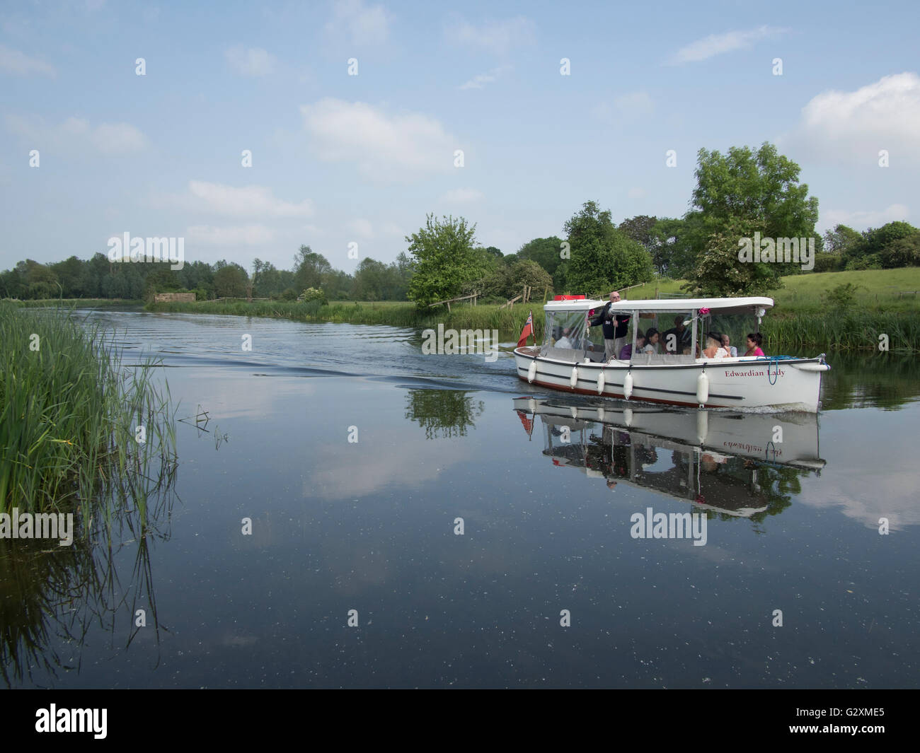 People enjoying a boat cruise on the River Stour in Sudbury, Suffolk, England. Stock Photo