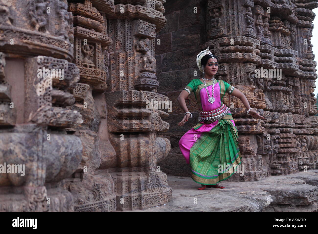 odissi dancer depicting drum play at konark temple in odisha Stock Photo