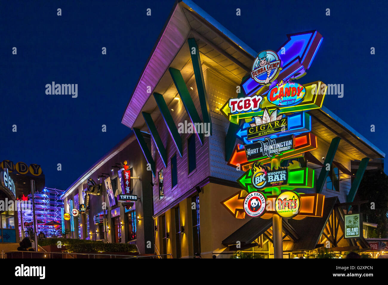Brightly colored neon signs guide tourists through City Walk at Universal Studios in Orlando, Florida Stock Photo