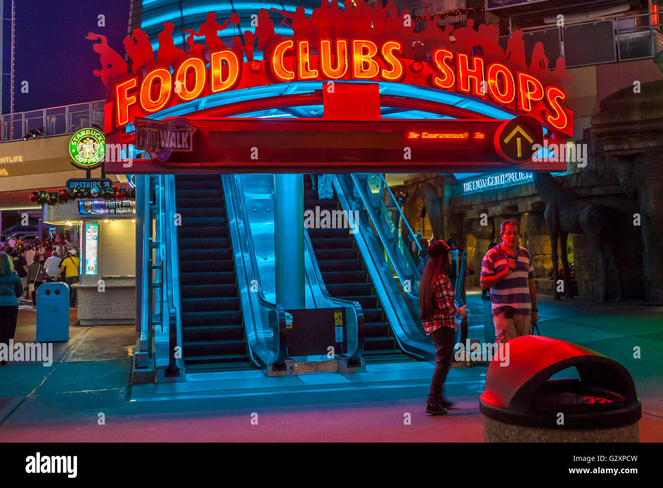Brightly colored neon signs light escalator to restaurants. clubs,  and shops at Universal Studio's City Walk in Orlando, FL Stock Photo