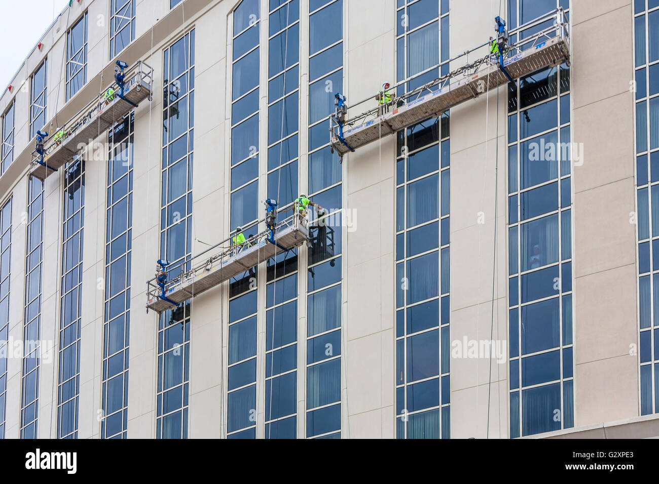 Window washers on electric scaffolding cleaning windows on high rise building in Nashville, Tennessee Stock Photo