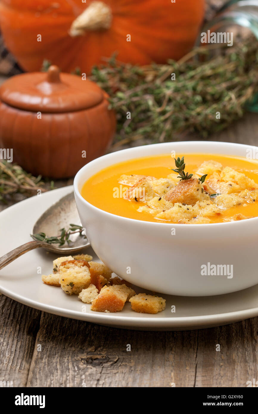 pumpkin soup - puree with croutons  in a white bowl on the old wooden background Stock Photo