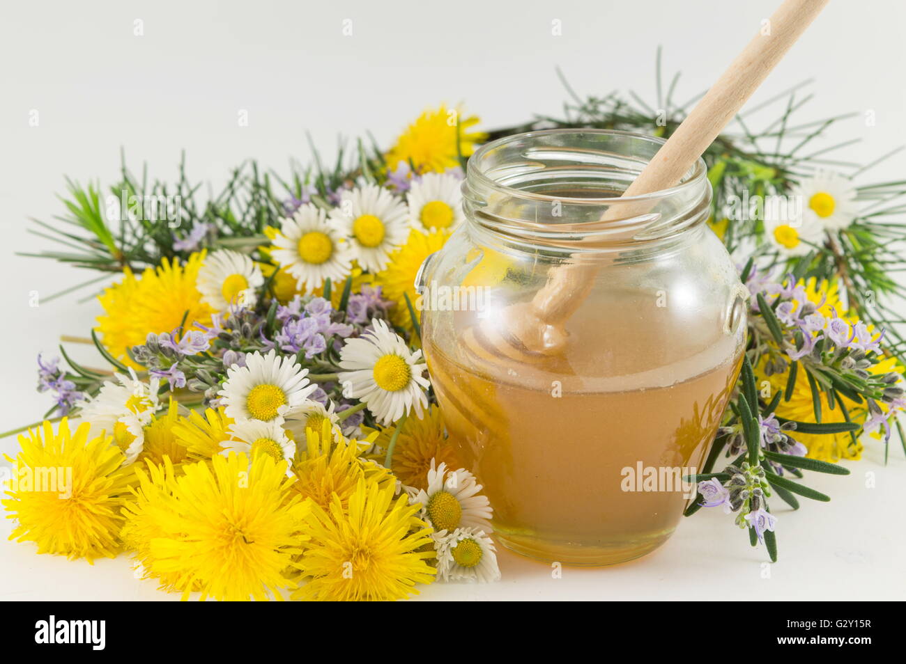 Fresh flowers and a jar of sweet honey Stock Photo