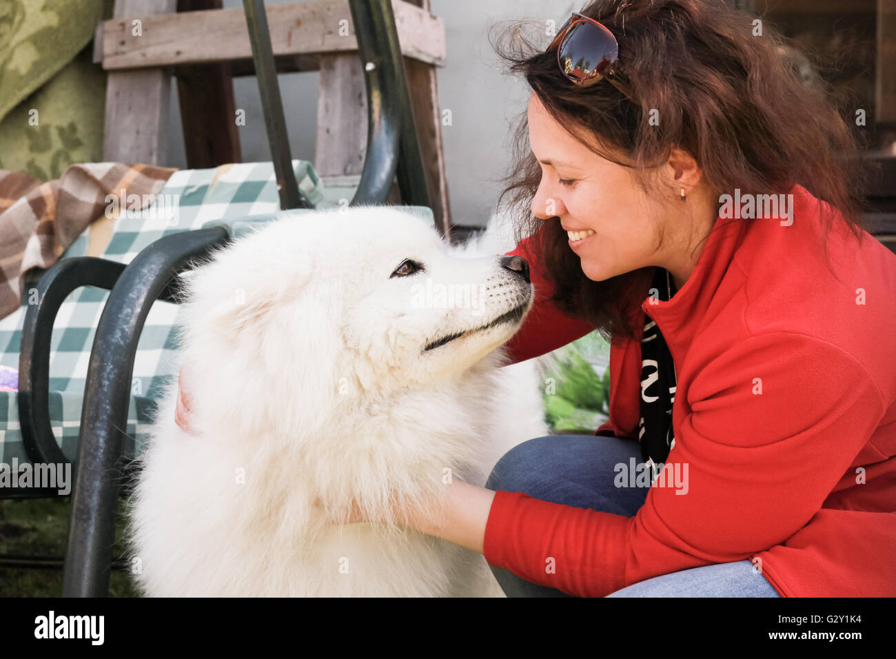 Happy young woman with white fluffy Samoyed dog Stock Photo