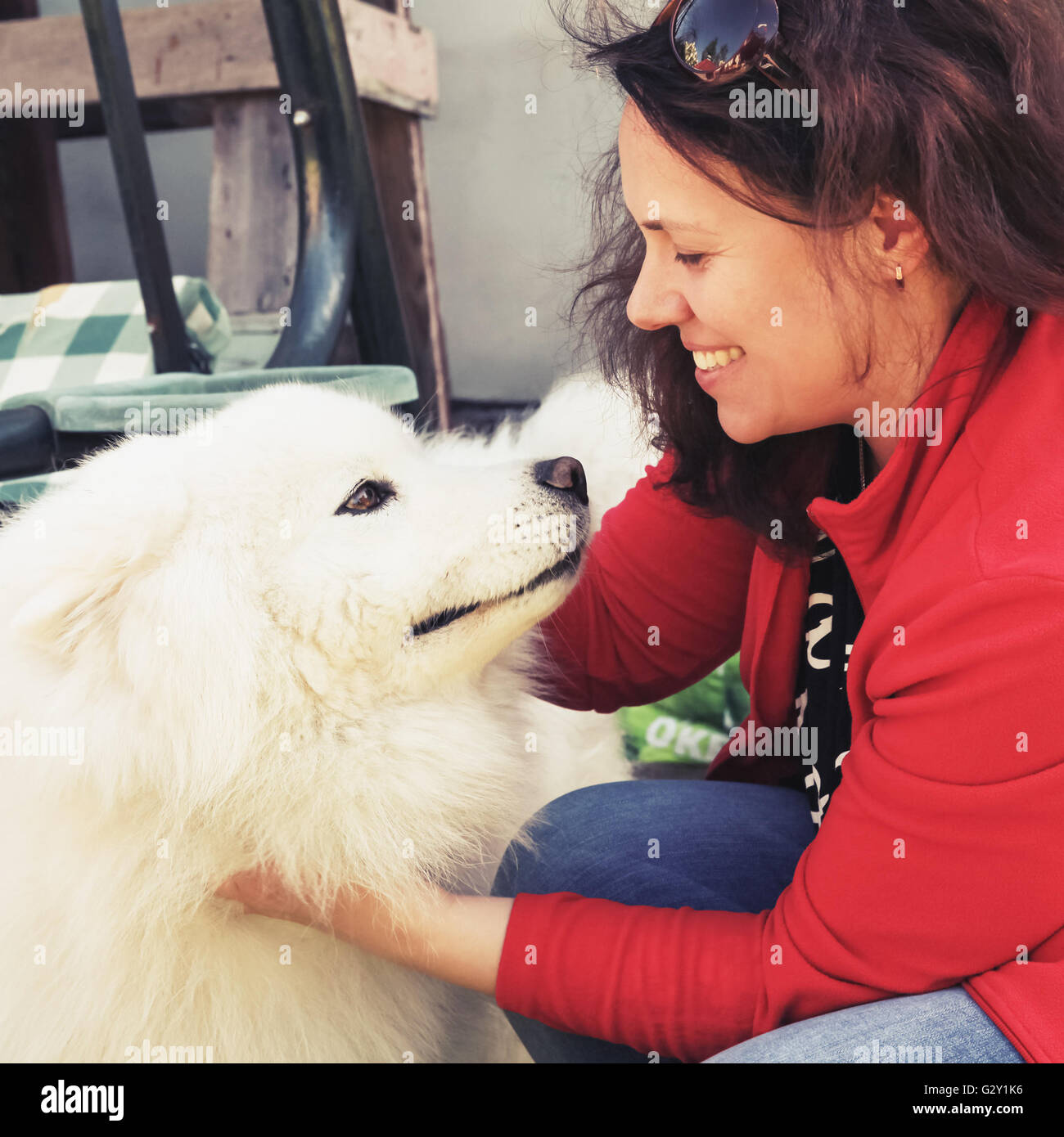 Happy young woman with white fluffy Samoyed dog, old style square photo with tonal correction filter effect Stock Photo