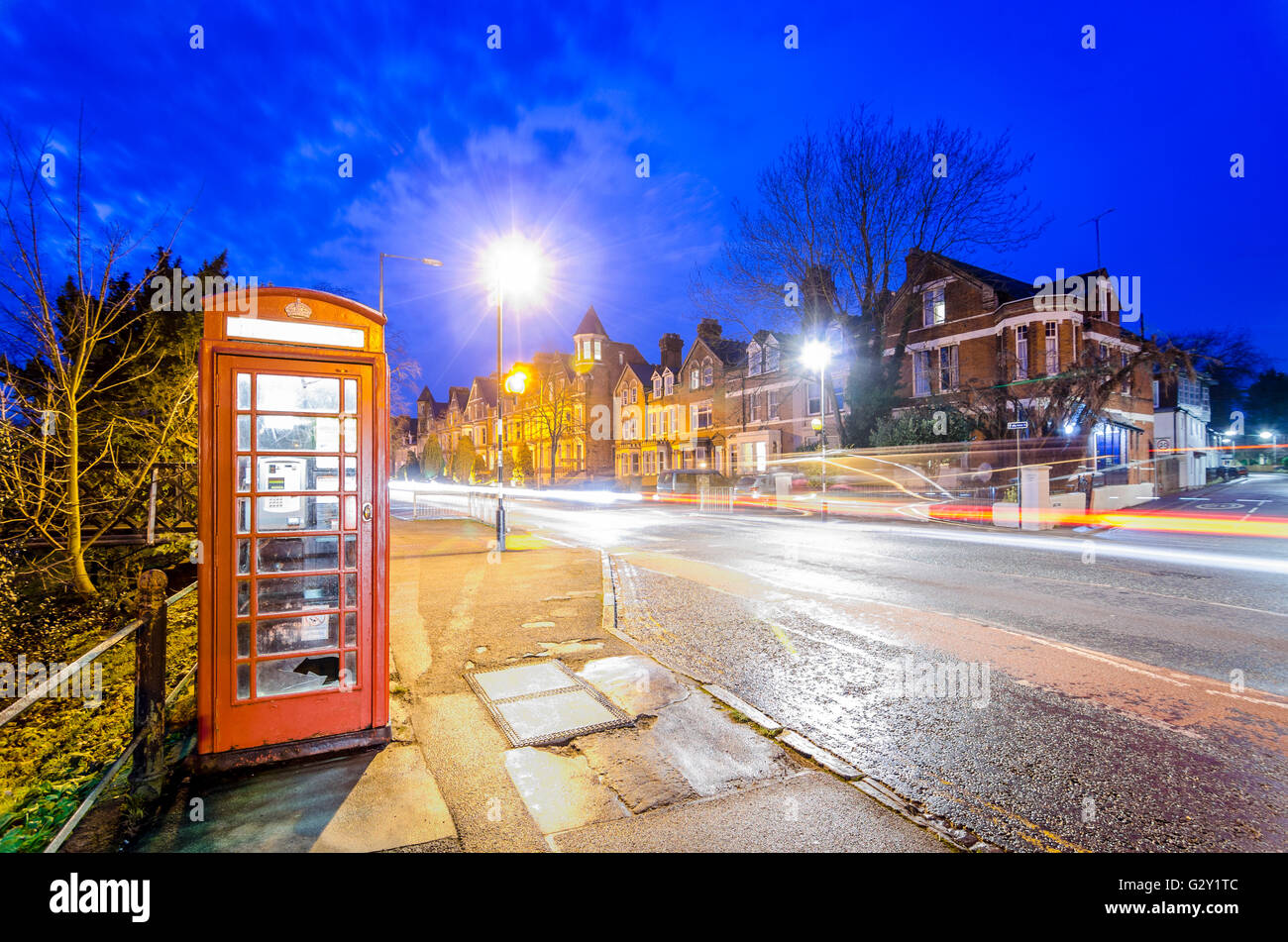Night scene in Cambridge, UK, with red telephone box and motion blur light trails Stock Photo