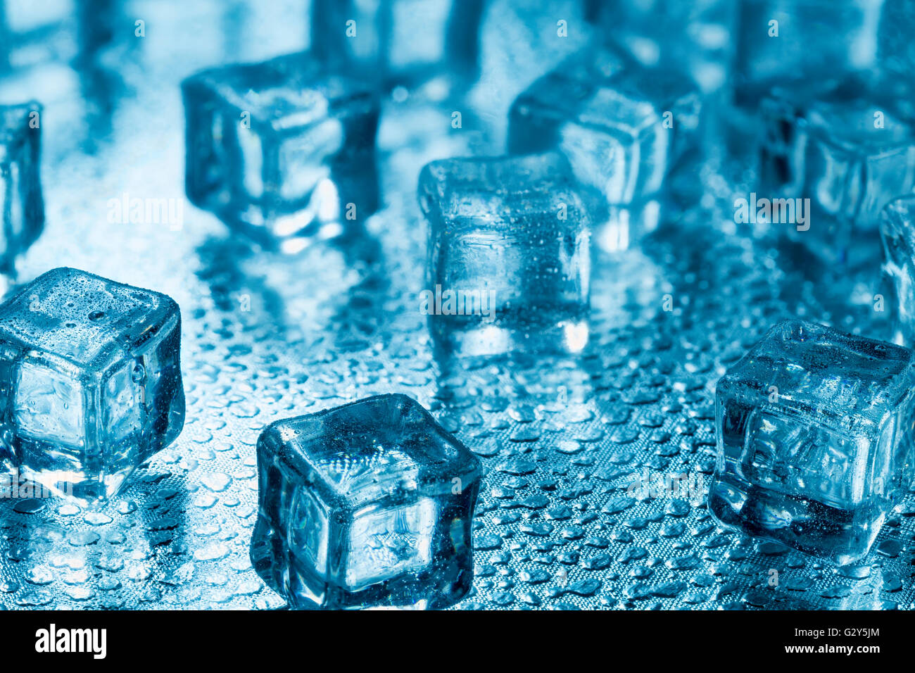 Many blue melting ice cubes on glass Stock Photo