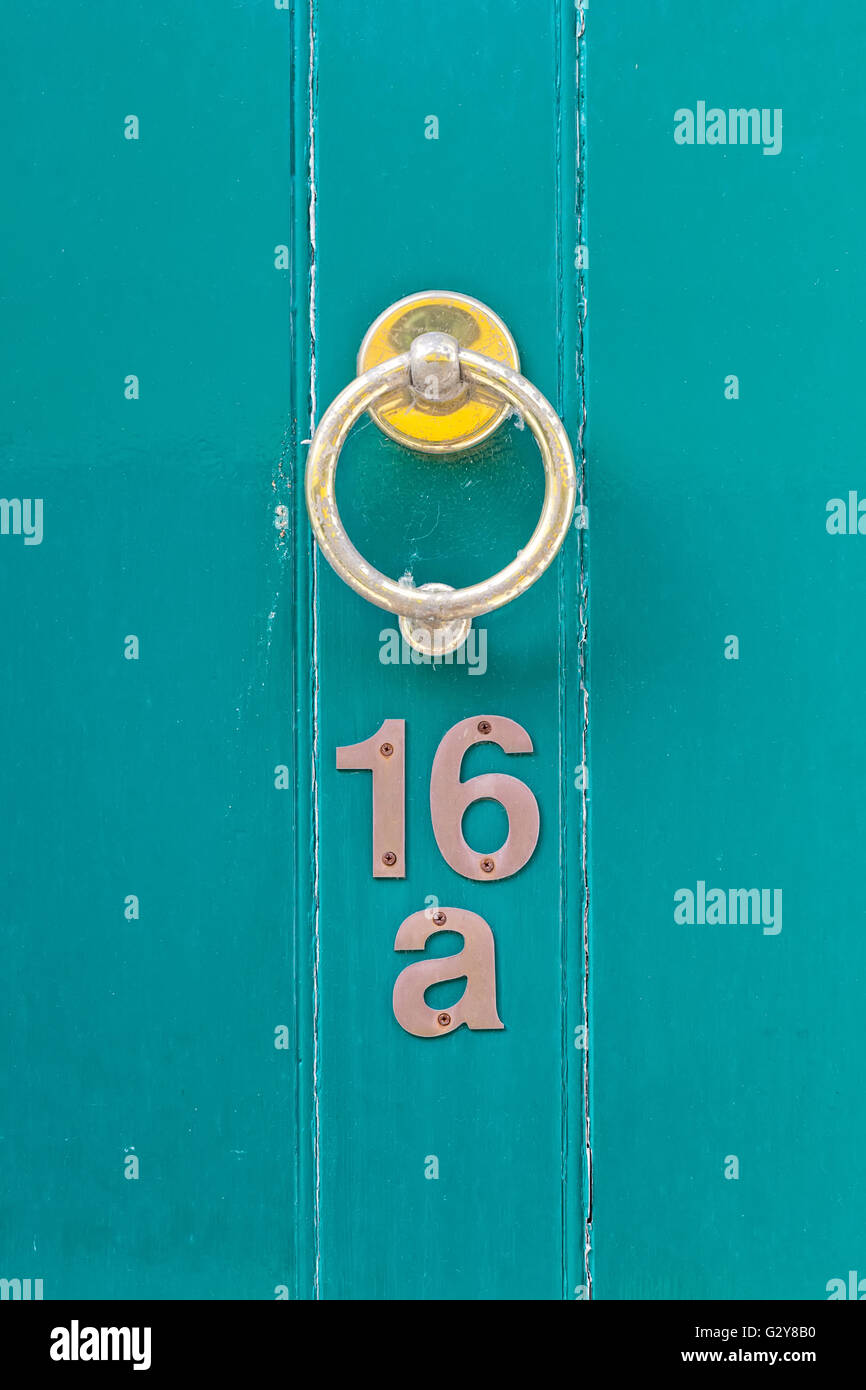 Light blue English period wooden front door with ornate iron door