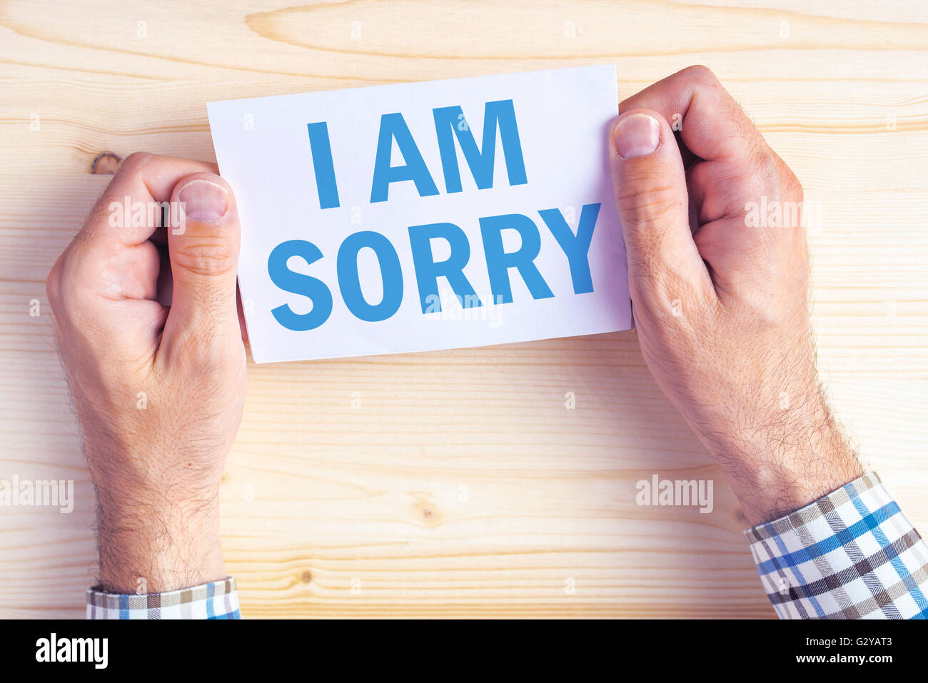 I am sorry message, top view of male hands holding apologizing card Stock Photo