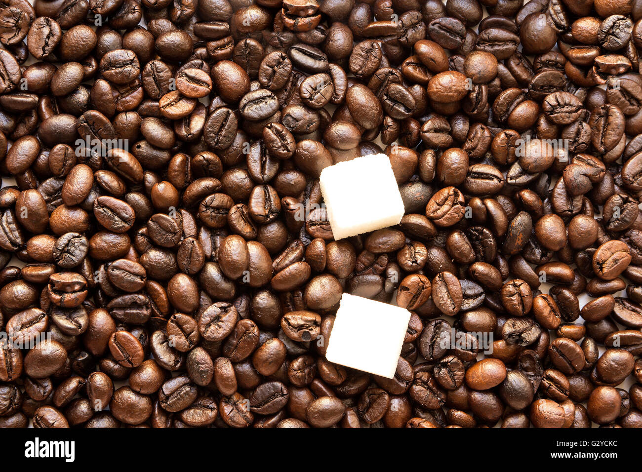 pieces of white sugar in coffee roasted beans Brown background Stock