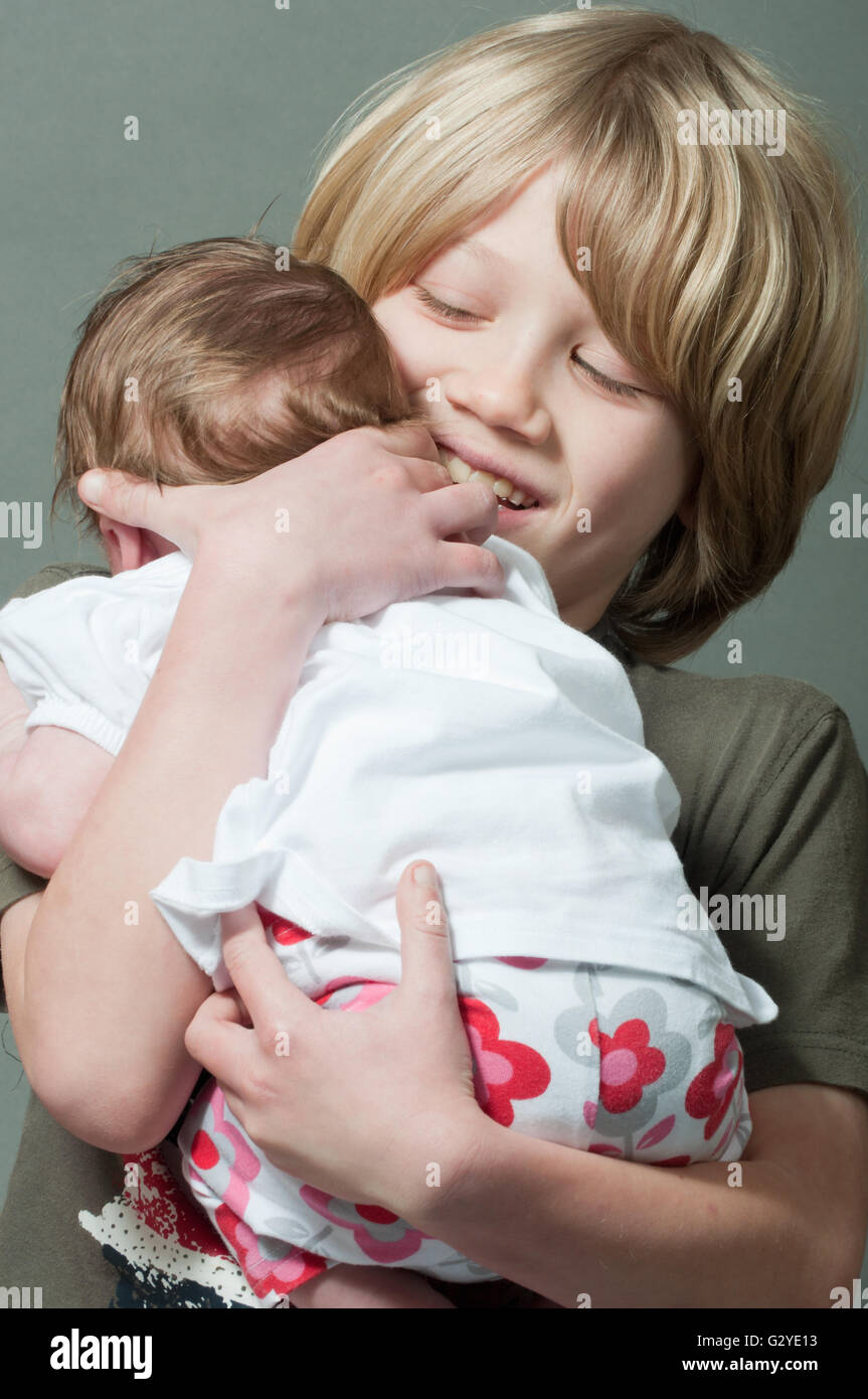 happy little boy holding a baby Stock Photo Alamy