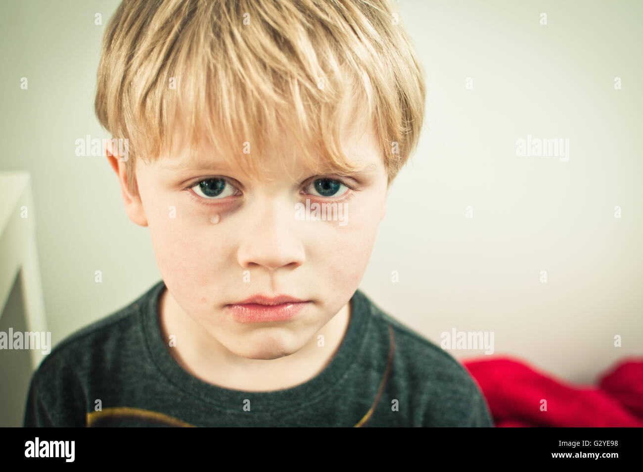 Lonely little boy with a sad face crying Stock Photo