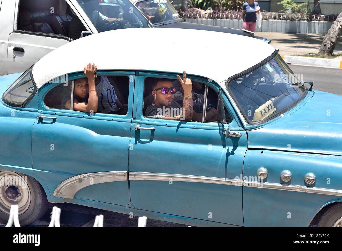 May 14, 2016 - Havana, Havana, Cuba - Passengers in a Cuban version of ''ride sharing'' in a vintage car in Havana. The Economic reality of the effects of the 56 year American Economic Blockage of Cuba is reflected in the historic building facades, antique automobiles, and the dilapidated living conditions of the Cuban people, Havana, Cuba, May 2016...The United States imposed a commercial, economic, and financial blockade against Cuba on Oct. 19,1960 (in Cuba called el bloqueo, Ã’the blockadeÃ“). A blockade is economic warfare as defined by the Oxford Dictionary. The Cuban blockade is the mos Stock Photo