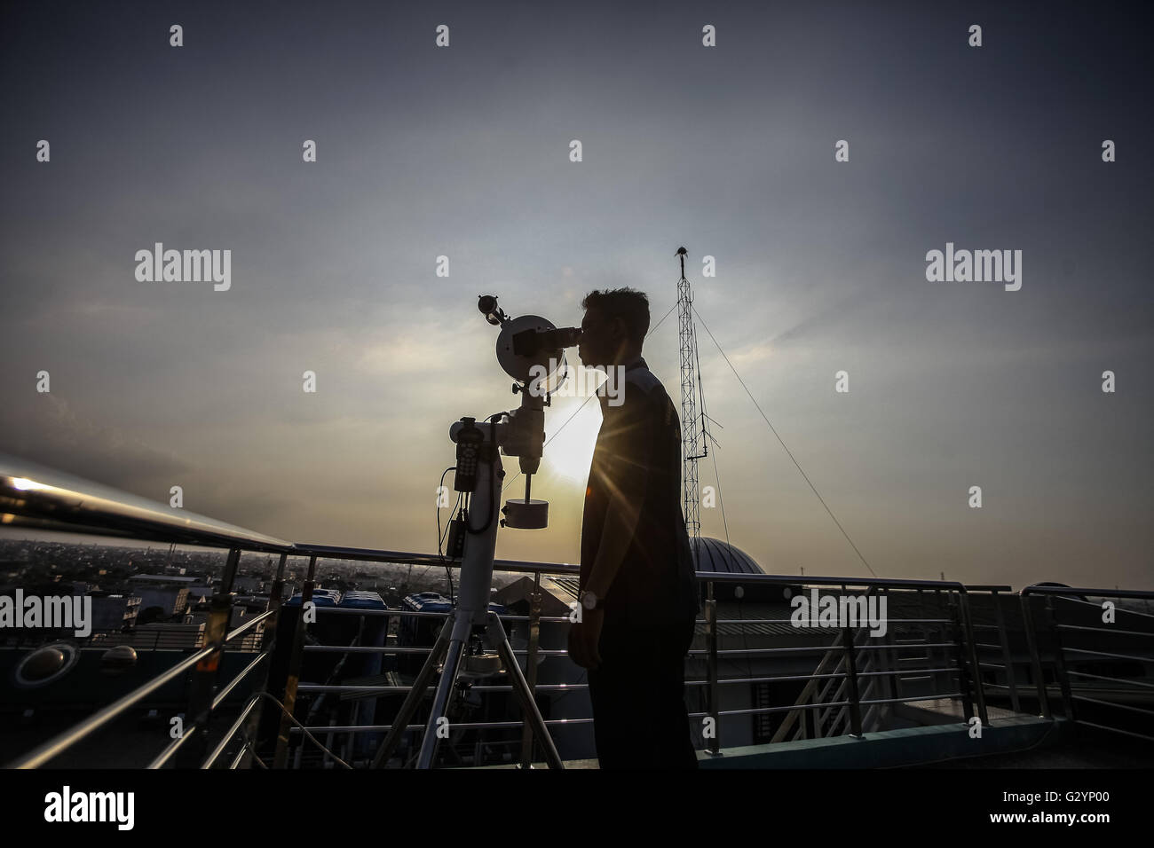 Medan, Indonesia. 5th June, 2016. A man looks through a telescope to determine the sighting of the new moon to mark the start of the fasting month of Ramadan in Medan, Indonesia, June 5, 2016. © YT Haryono/Xinhua/Alamy Live News Stock Photo