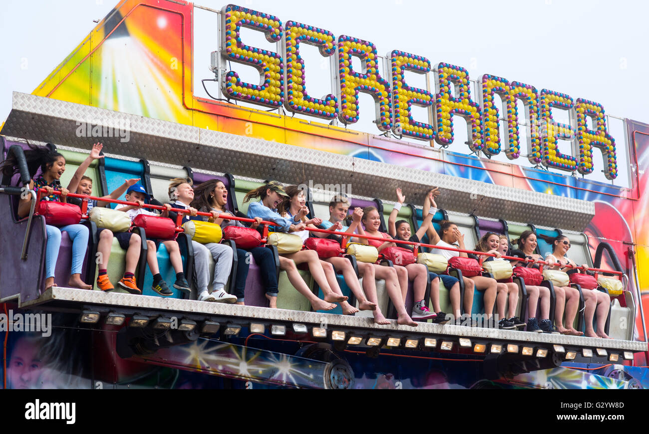 Excited children waiting to be frightened and thrilled on a Screamer funfair ride. Stock Photo