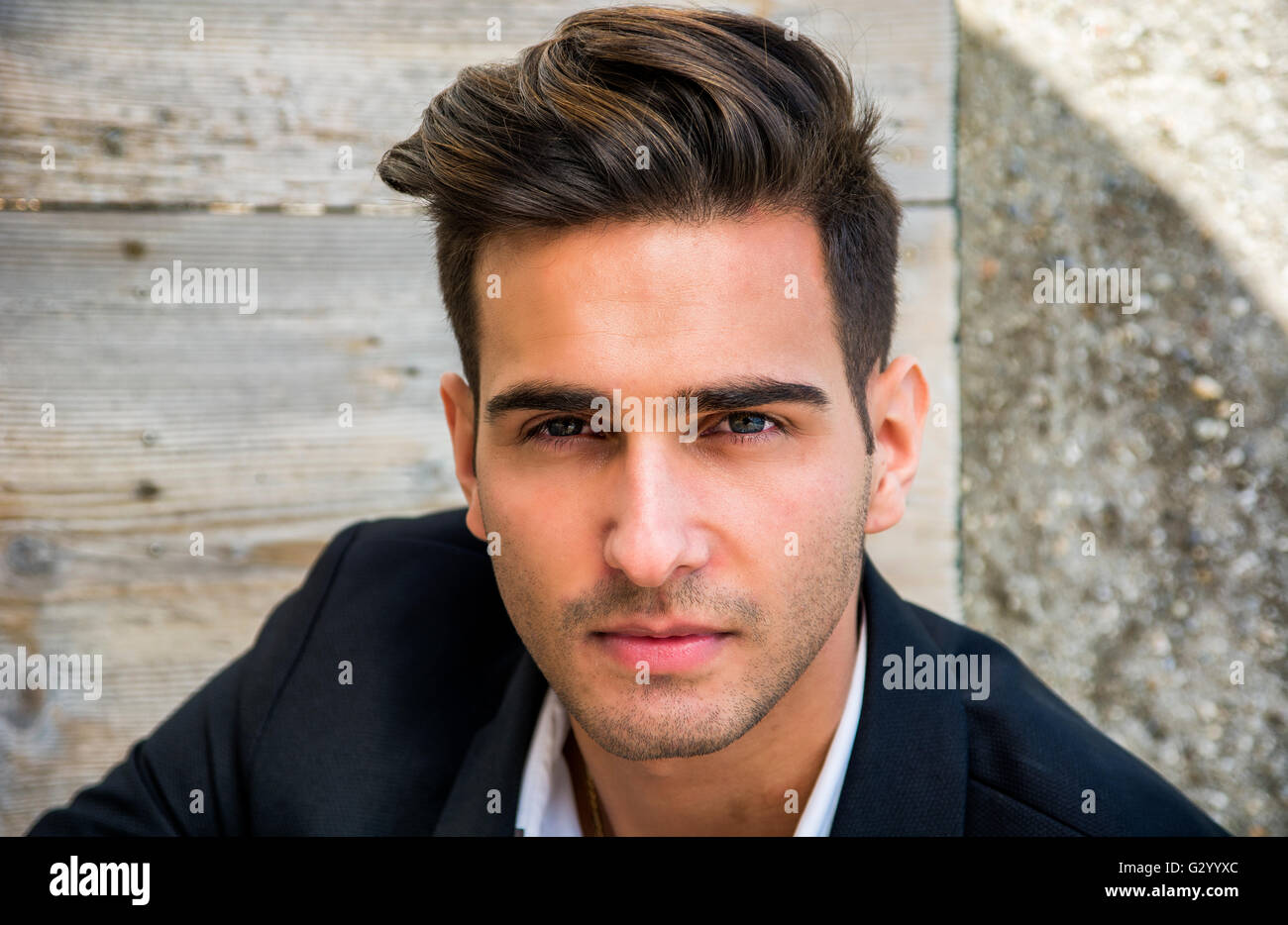 Headshot of handsome young man in city street, looking at camera Stock Photo