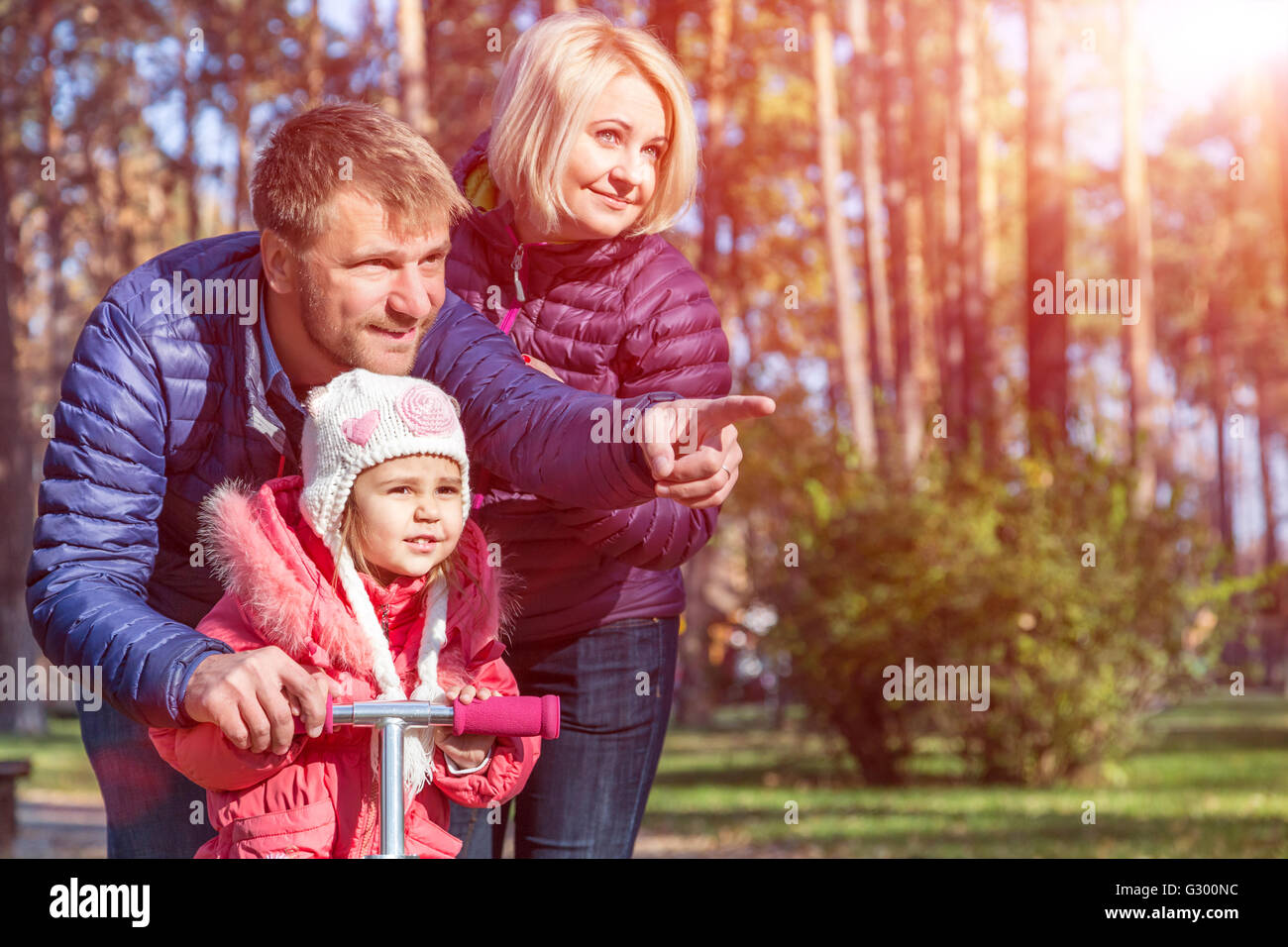 Young Family in Autumnal Forest Pointing Stock Photo