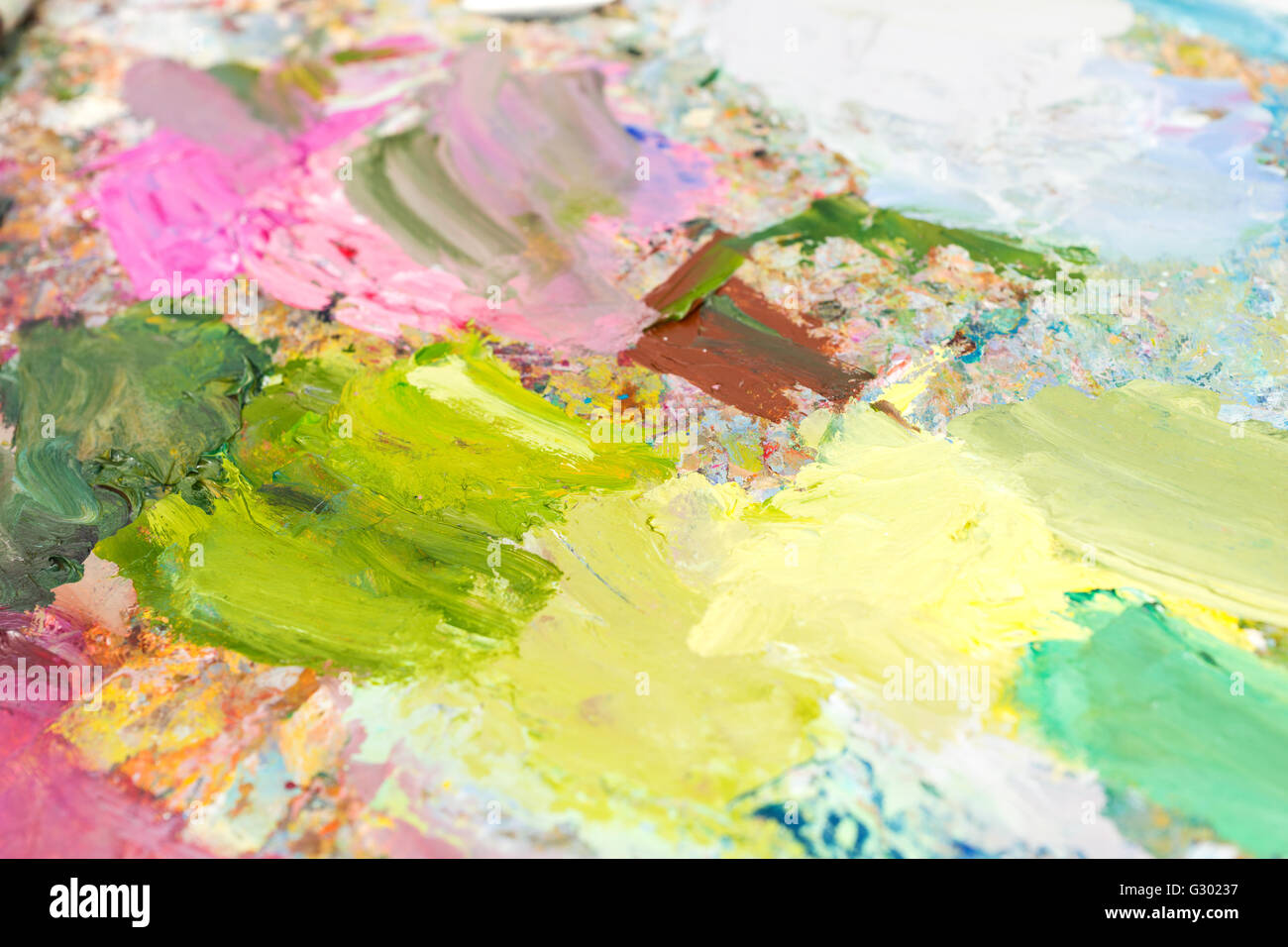 Bright blended oil paint on a palette on a milticolored professional