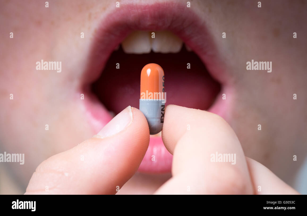 A boy taking an antibiotic tablet Stock Photo