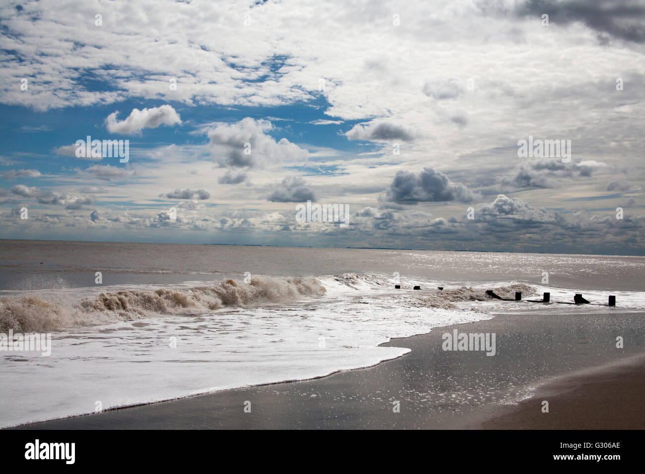 Storm clouds clearing the beach with wind farm in the background Skegness Lincolnshire England Stock Photo