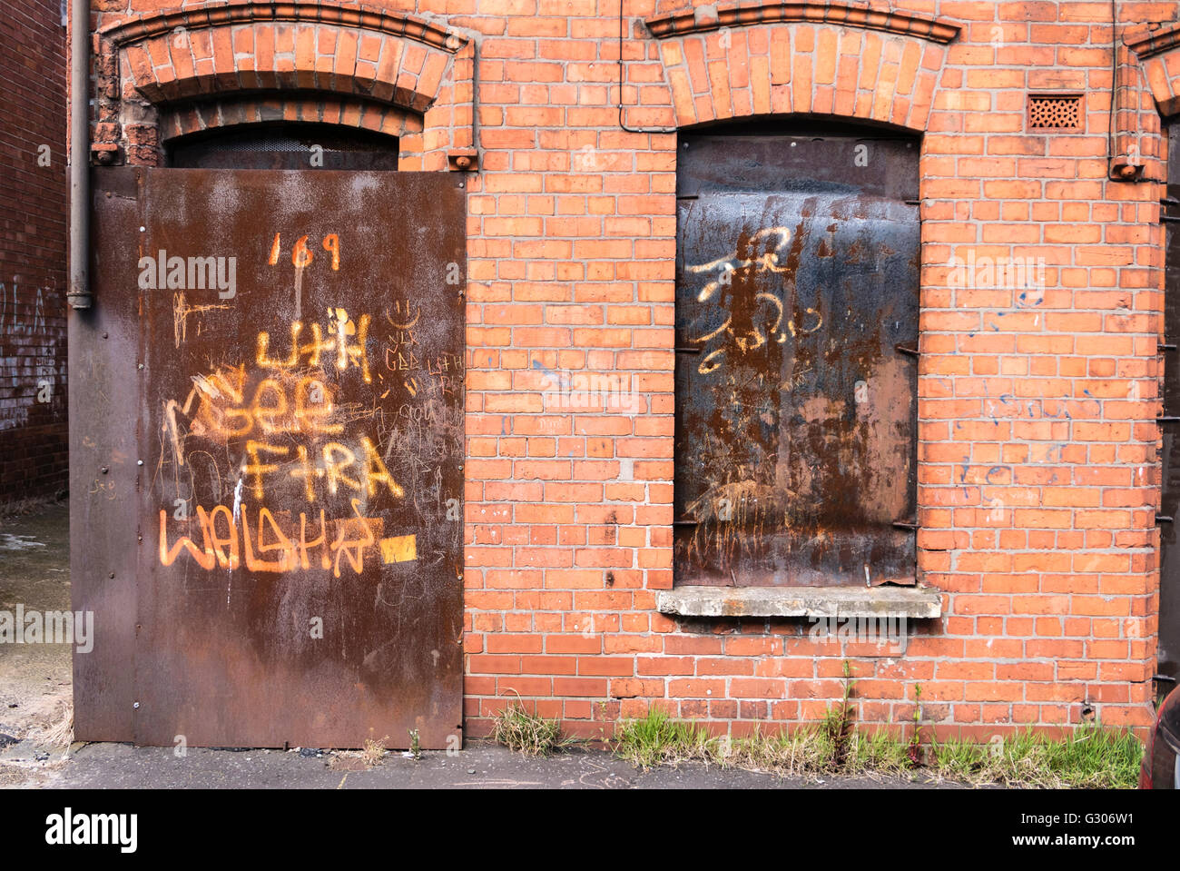 Derelict house boarded up with steel plates. Stock Photo