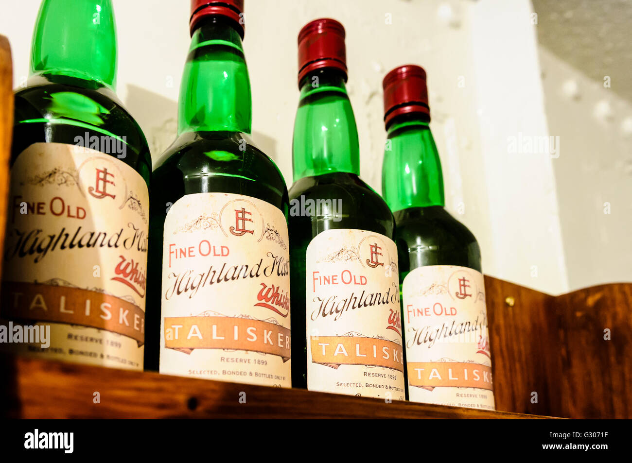 Four bottles of Talisker Highland Malt Whiskey on a wooden shelf. Stock Photo