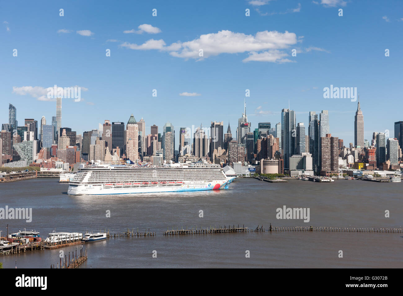 Cruise ship Norwegian Breakaway heads south on the Hudson River past the mid-town skyline of New York City. Stock Photo