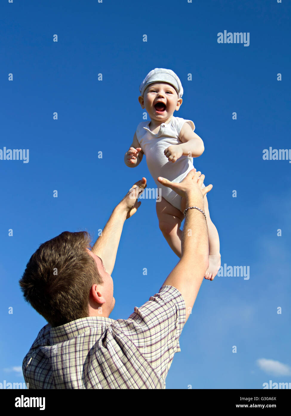 Father tossing baby in the air Stock Photo