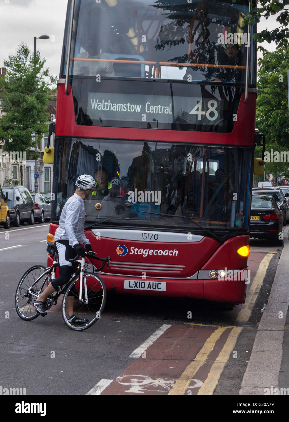 A cyclist blocking the path of a London double-decker bus and arguing with the driver, Lea Bridge Road, Leyton, London, England Stock Photo