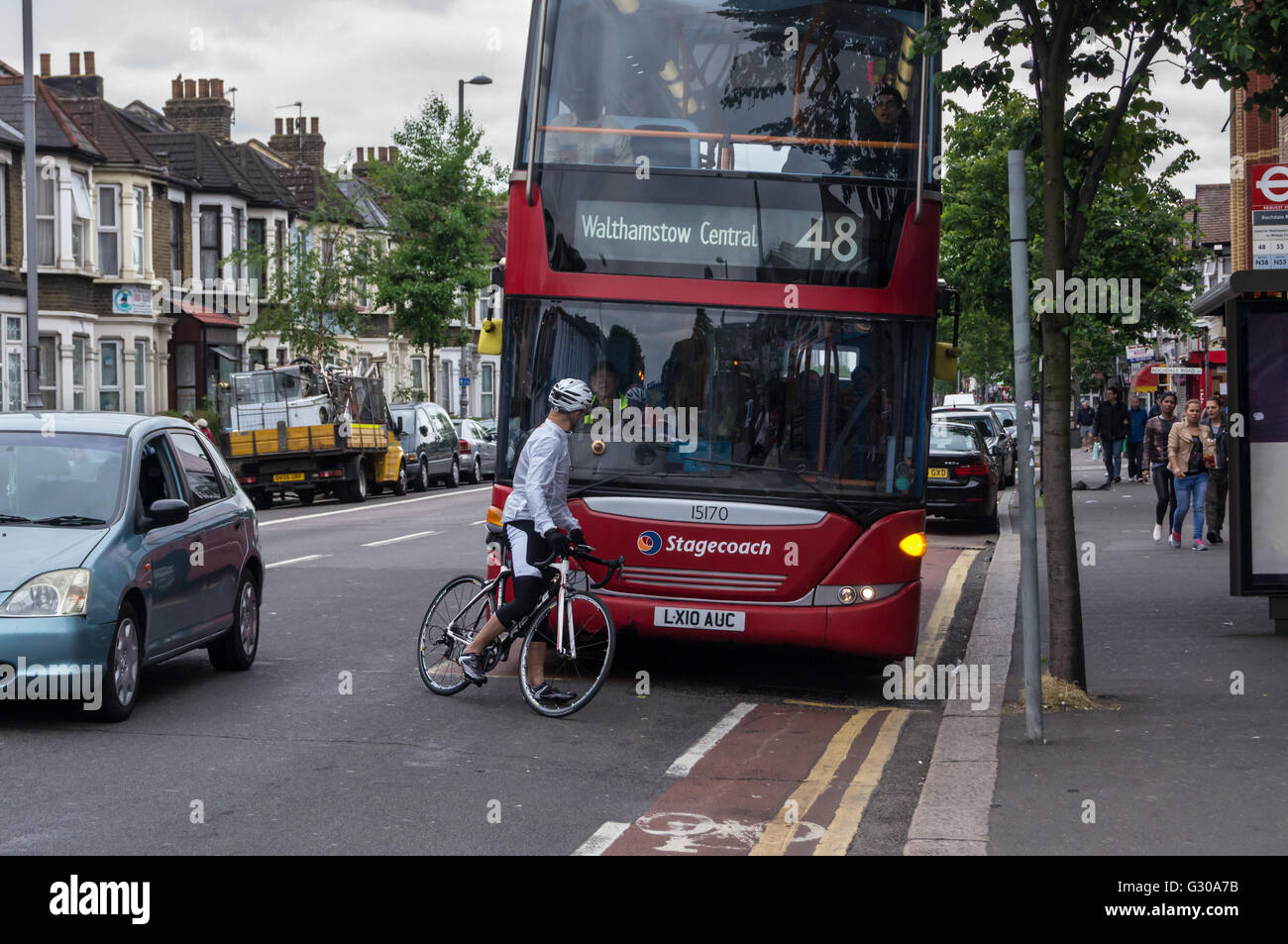 A cyclist blocking the path of a double-decker bus and arguing with the driver, Lea Bridge Road, Leyton, London, England Stock Photo