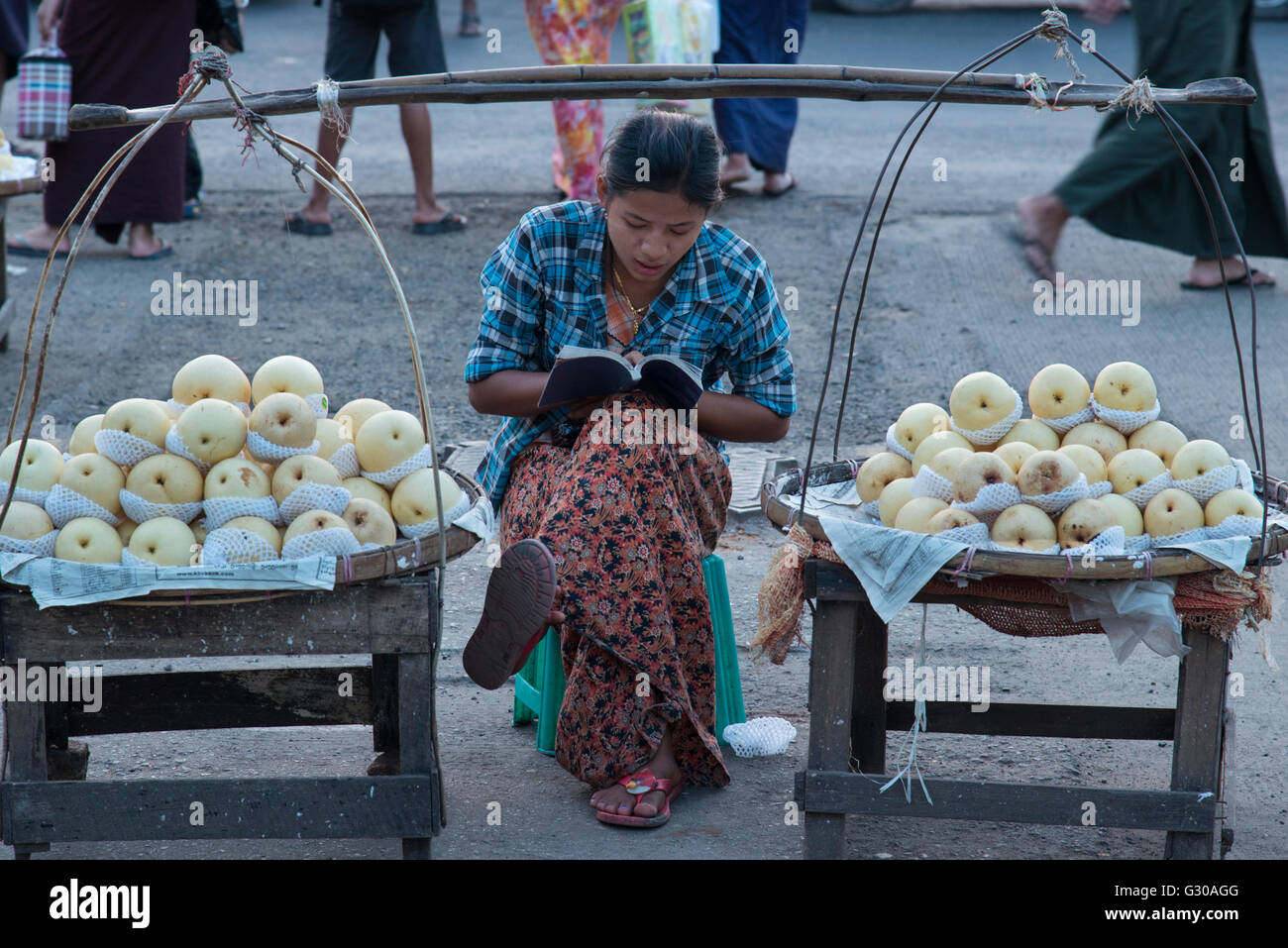 Young woman selling apples from a portable stall in the streets of Yangon (Rangoon), Myanmar (Burma), Asia Stock Photo