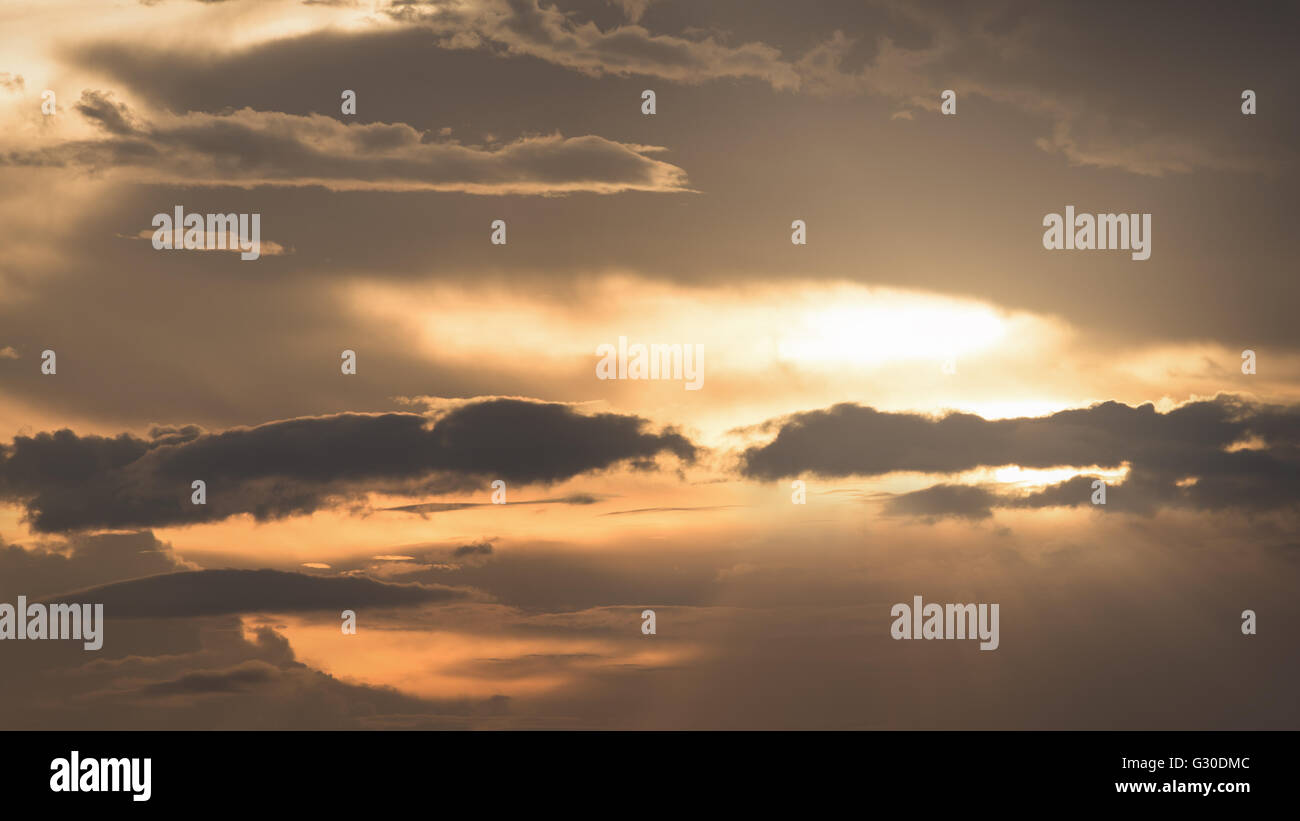Background of golden sky from sun behind plenty of cloud before sunset Stock Photo