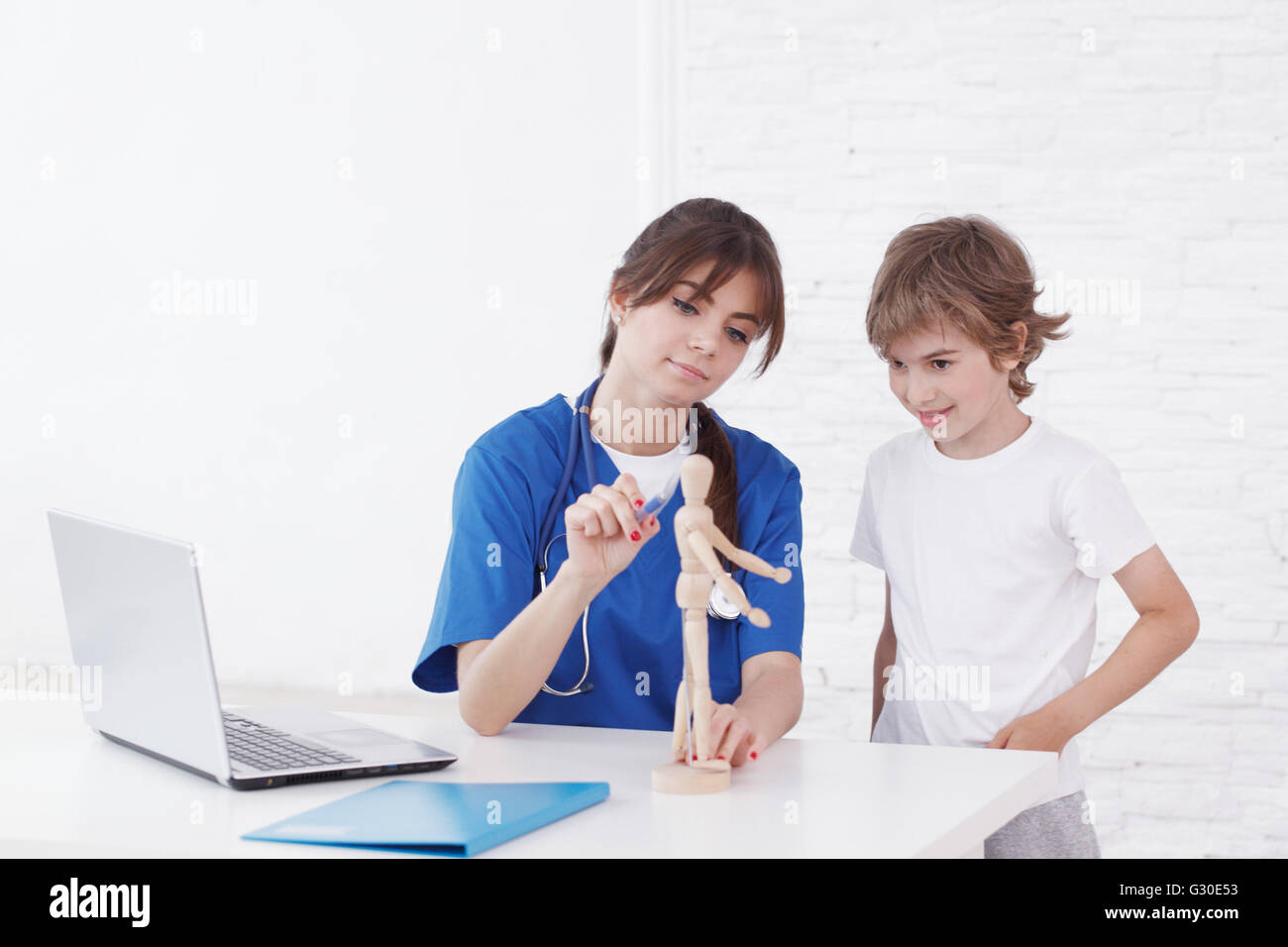 Doctor explain medicine to child using wooden doll Stock Photo