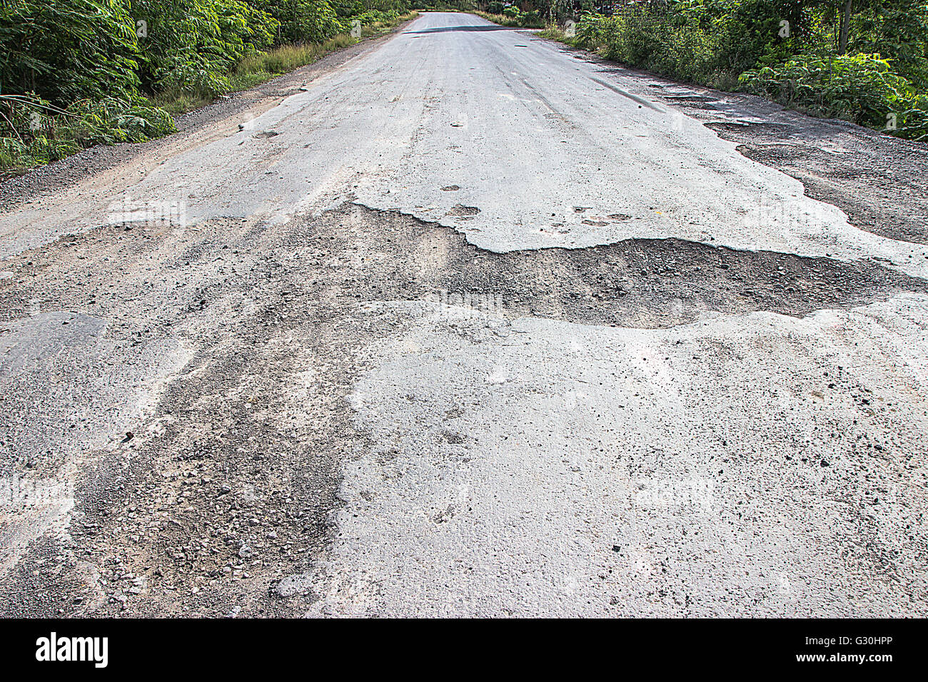 Damaged road in the countryside, damaged asphalt road with potholes
