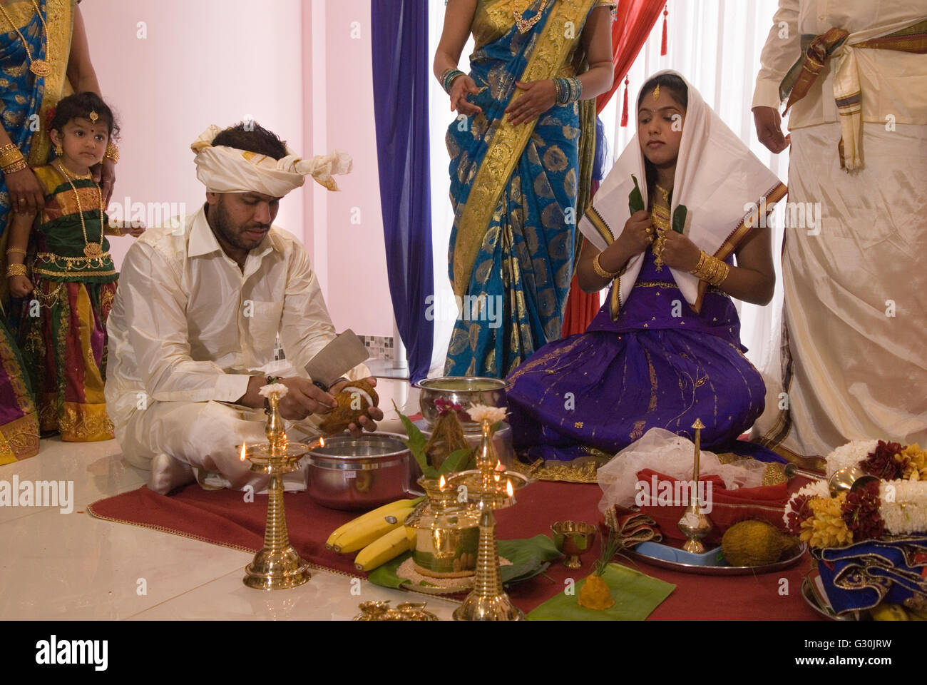 Hindu family in London celebrate their 16 year old daughters coming of age party. Ritushuddhi,  also called as Ritu Kala Samskara,   Coconut milk is poured onto her head by her brother. It  symbolises health and prosperity, family members stand by her side. Mitcham south London.  A celebration and the transition to womanhood.   2010s 2016 UK  HOMER SYKES Stock Photo