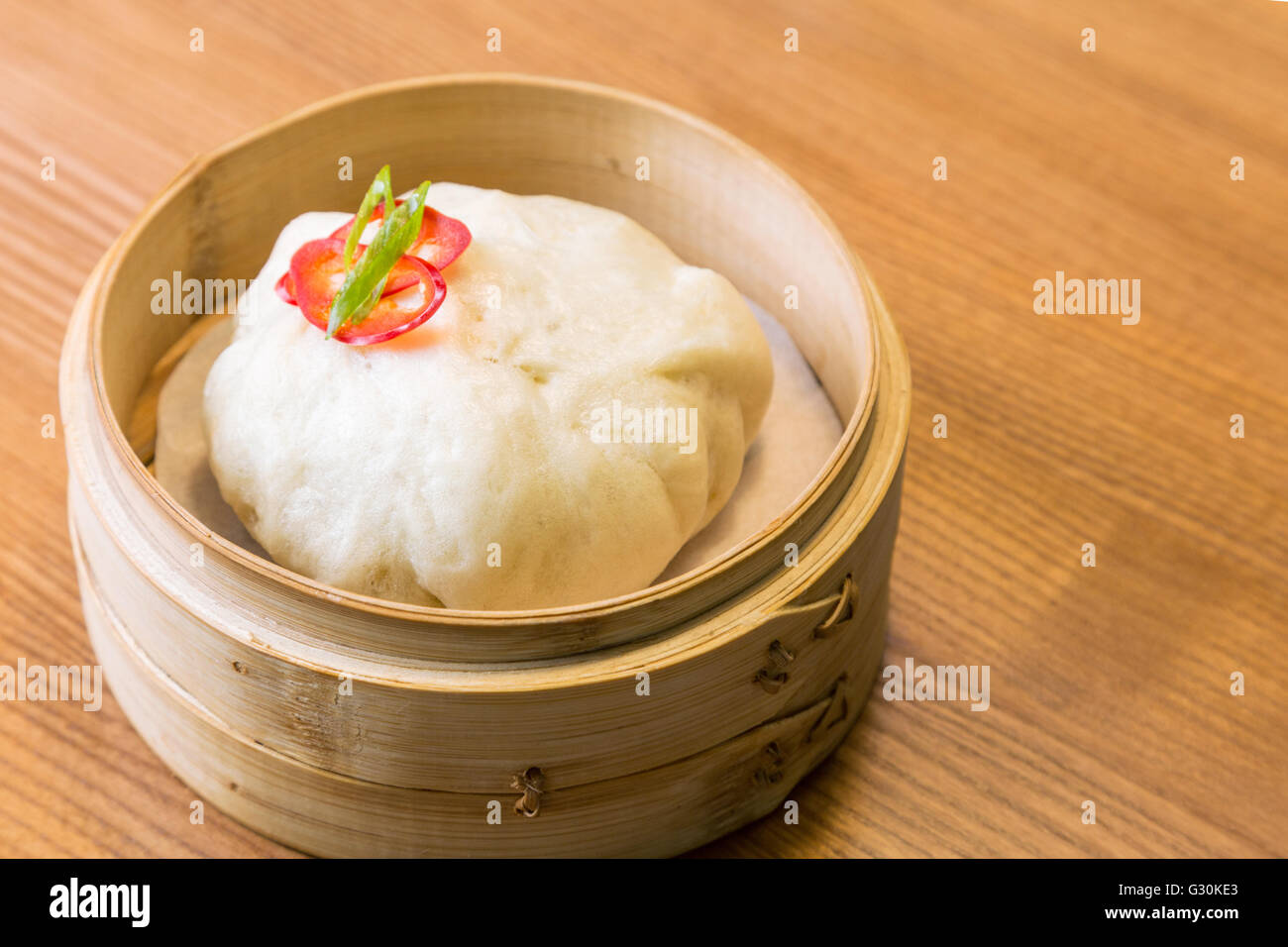 Asian steam bun in a bamboo steamer a wooden table Stock Photo