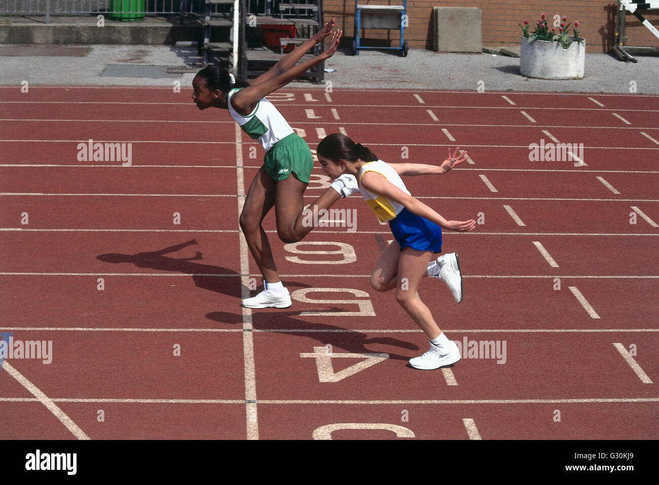 Two Girls Finishing a Race, at Finishing Line on Track. Stock Photo